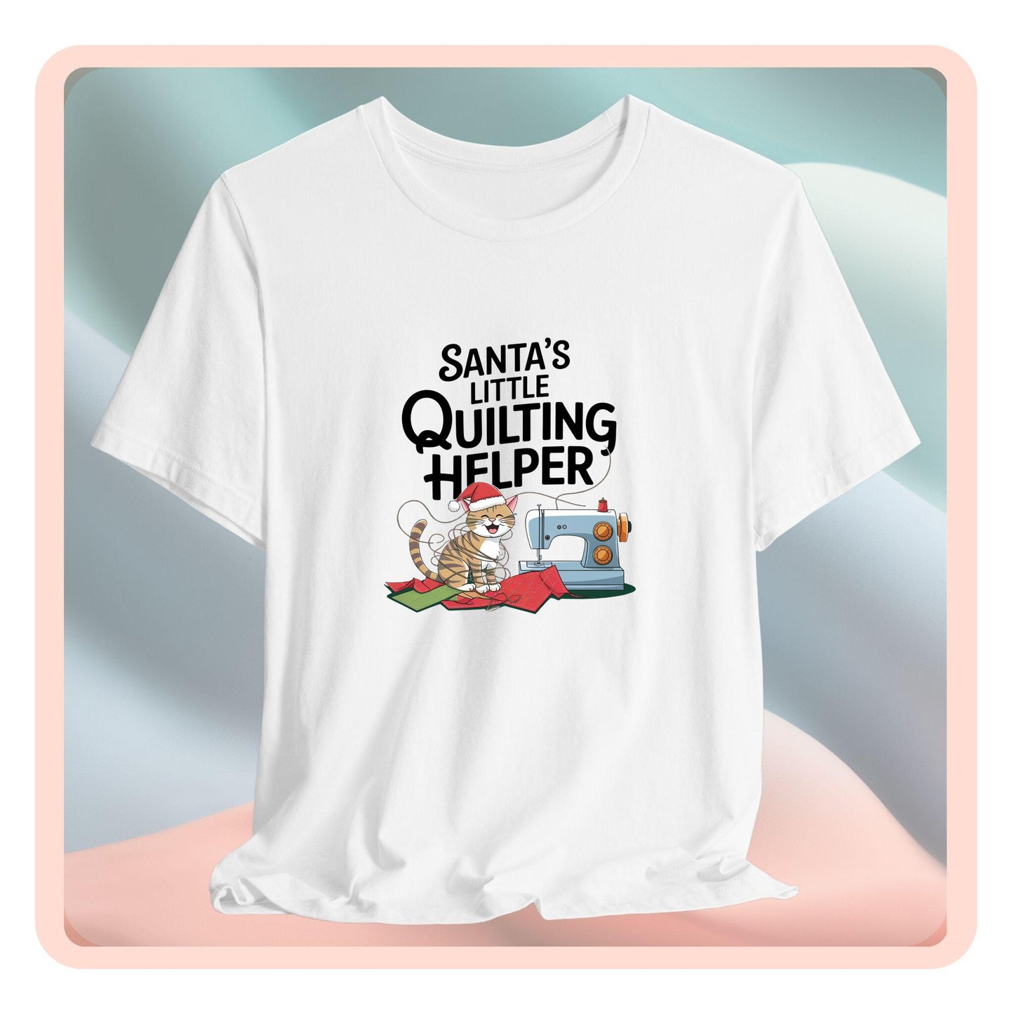 A christmas quilting t-shirt featuring a playful cat wearing a Santa hat is tangled in thread next to a sewing machine, with the phrase "Santa's Little Quilting Helper" above, combining quilting and holiday humor.
