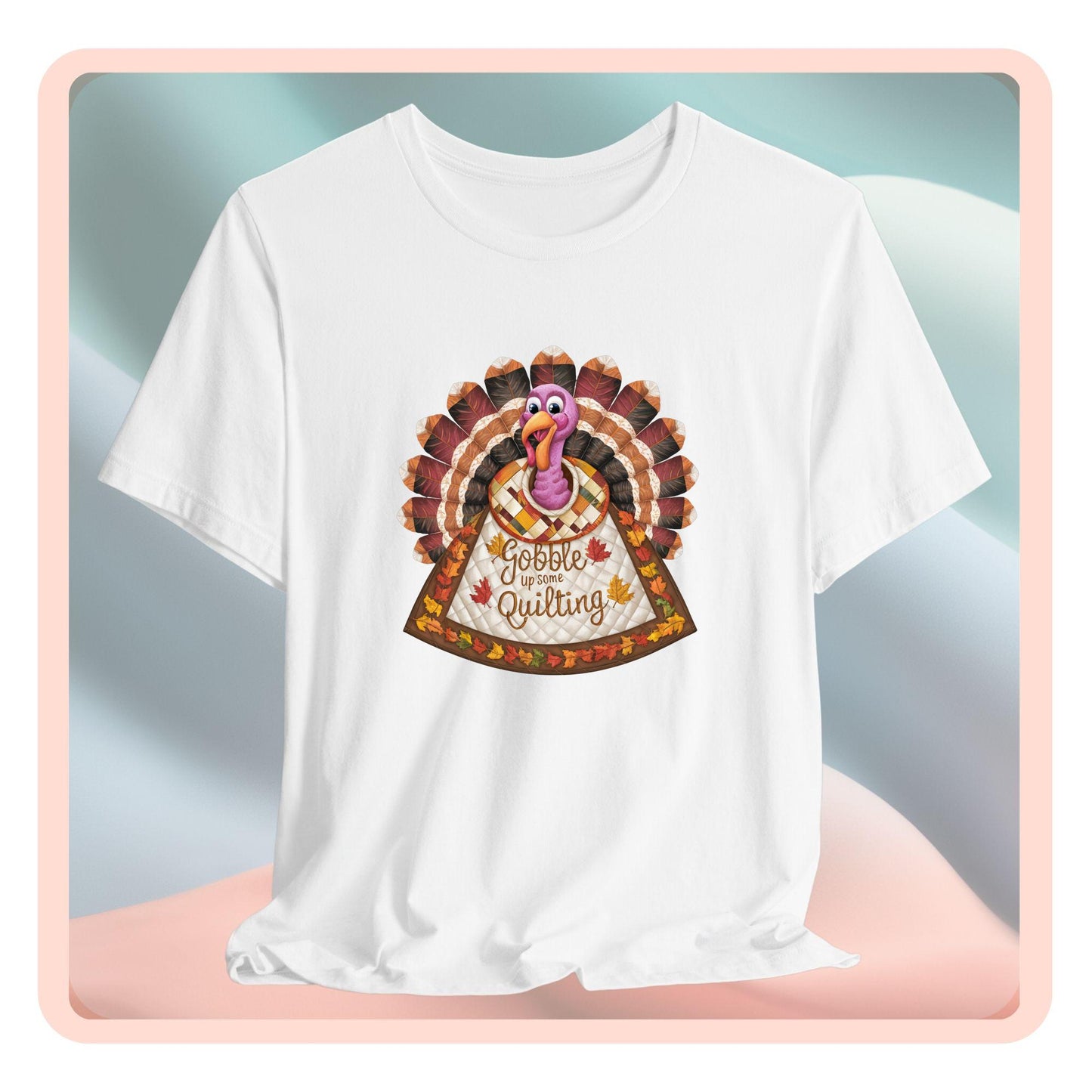 A thanksgiving quilting t-shirt featuring a quilted turkey design with colorful patchwork feathers and body. Text on turkey reads "Gobble up some Quilting" surrounded by fall leaves. Combines Thanksgiving imagery with quilting motifs in a whimsical illustration.