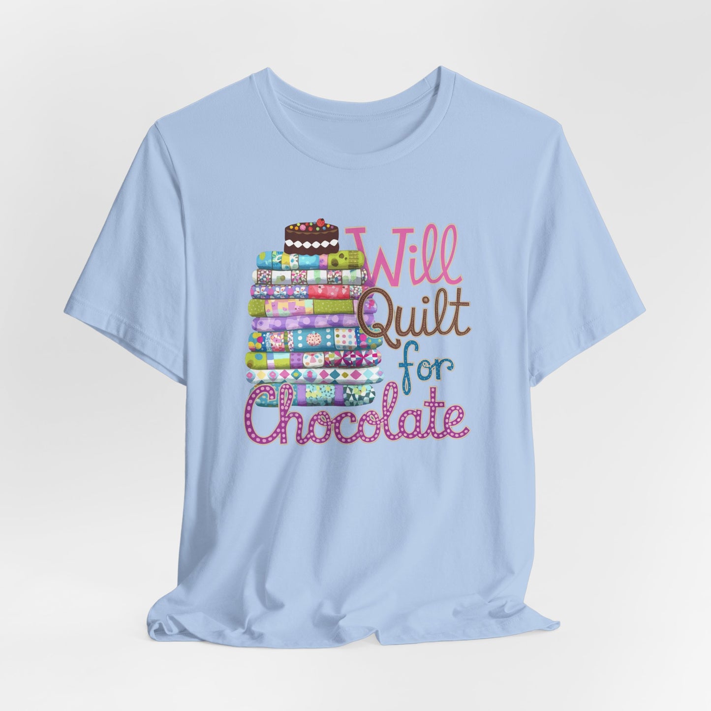 A Baby Blue t-shirt featuring a whimsical design of a colorful stack of quilts topped with a chocolate cake and the phrase 'Will Quilt for Chocolate,' perfect for quilters who love sweets.
