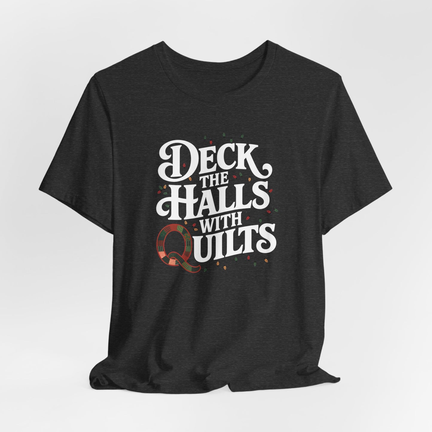 A Dark Grey Heather christmas quilting t-shirt featuring the phrase "Deck the Halls with Quilts," adorned with holiday lights and quilting-inspired elements, including a quilted 'Q' for a humorous touch.