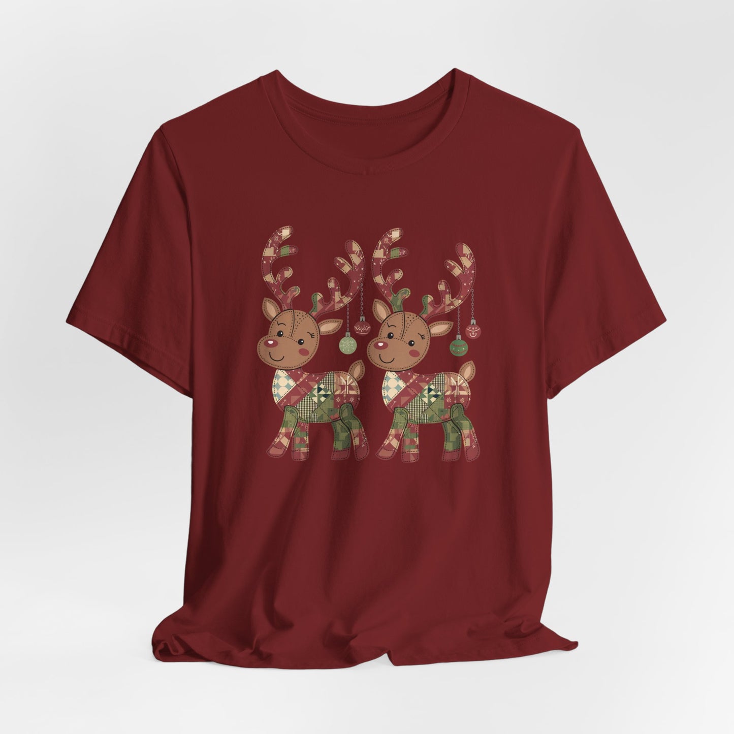 A Cardinal christmas quilting t-shirt featuring two adorable reindeer featuring patchwork quilt designs on their bodies, with ornaments hanging from their antlers, blending Christmas cheer with quilting creativity.