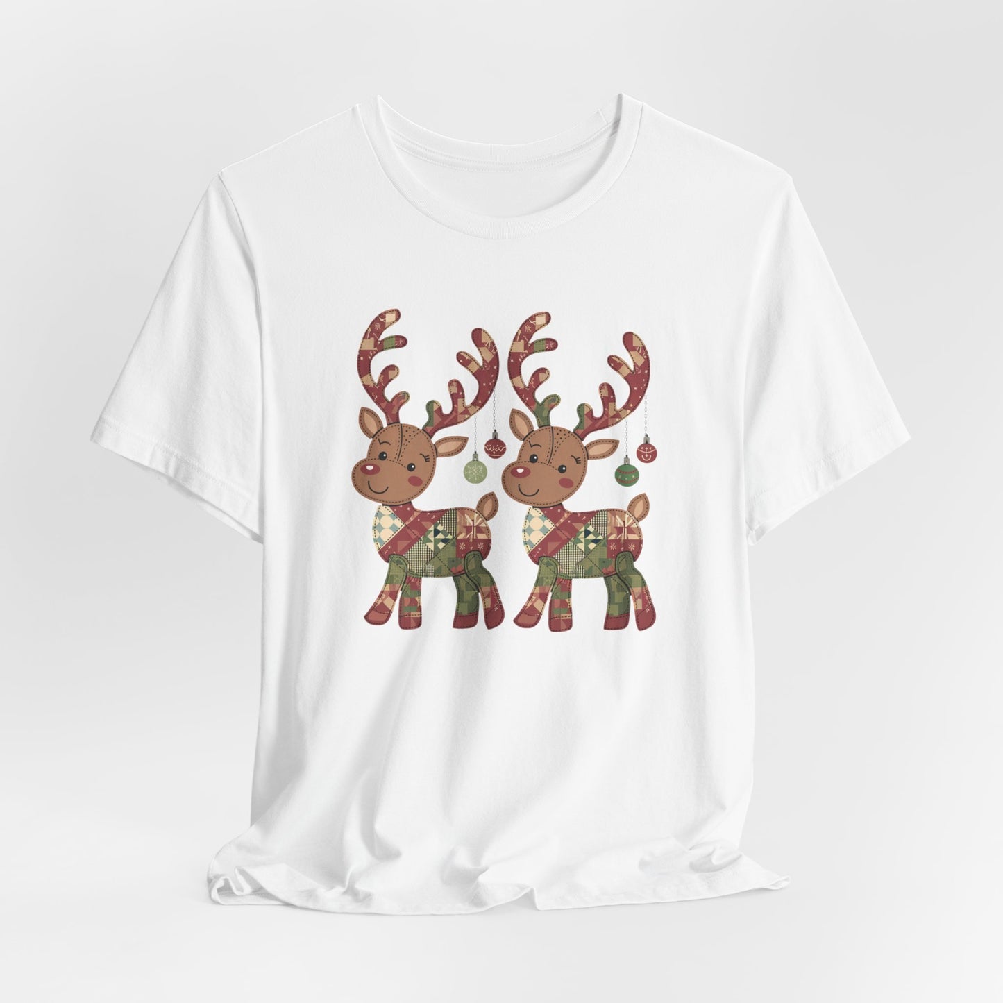 A White christmas quilting t-shirt featuring two adorable reindeer featuring patchwork quilt designs on their bodies, with ornaments hanging from their antlers, blending Christmas cheer with quilting creativity.