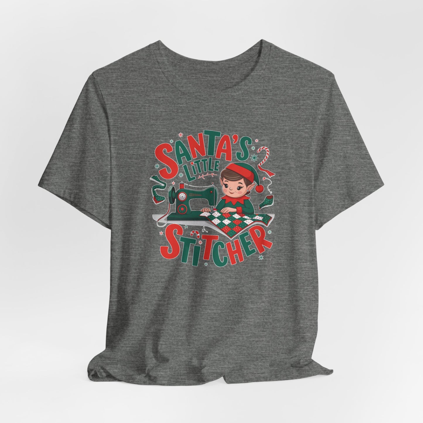 A Deep Heather christmas quilting t-shirt featuring an adorable elf is sewing a festive patchwork quilt on a sewing machine, surrounded by holiday-themed decorations, with the phrase "Santa's Little Stitcher" above and below the design.