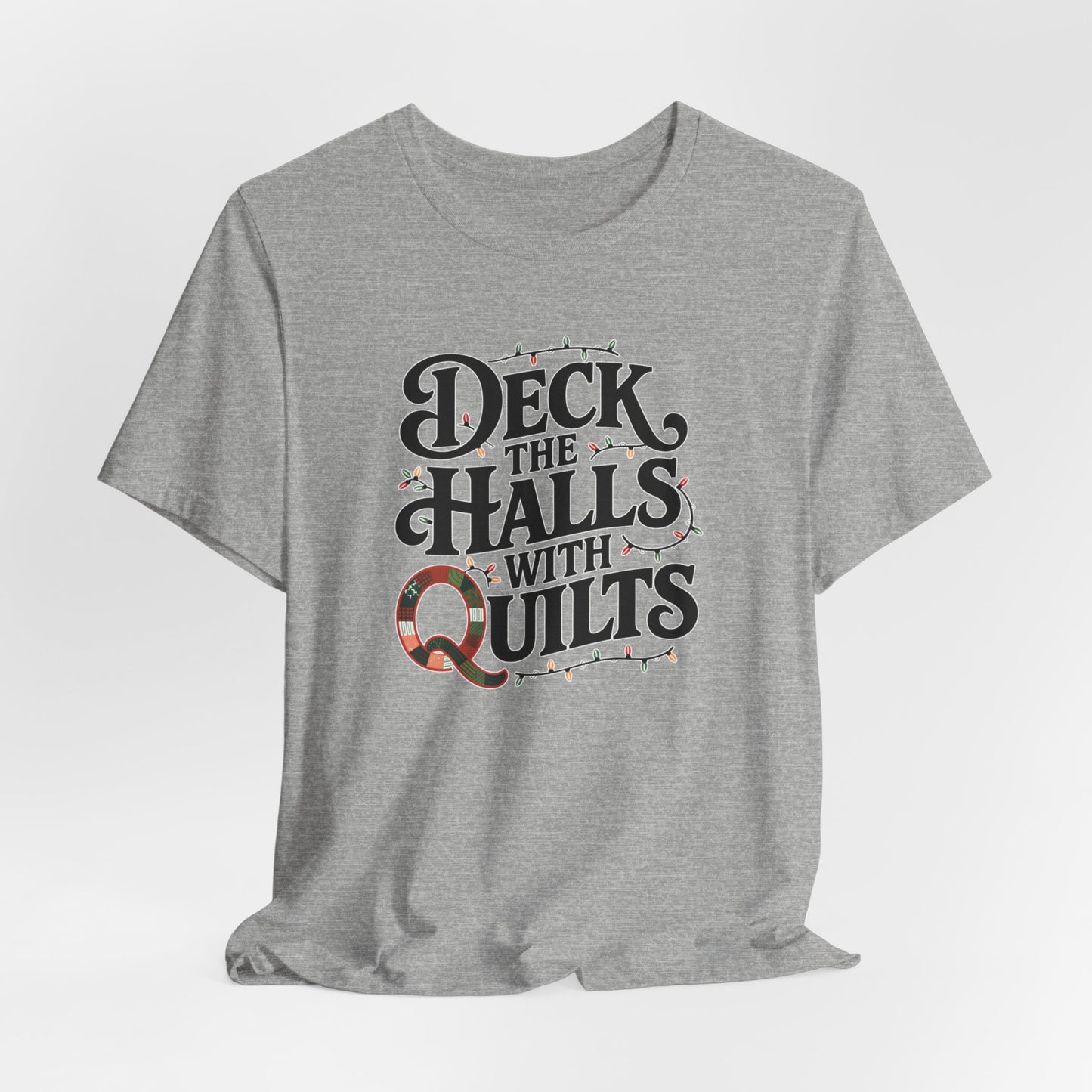 An Athletic Heather christmas quilting t-shirt featuring the phrase "Deck the Halls with Quilts," adorned with holiday lights and quilting-inspired elements, including a quilted 'Q' for a humorous touch.