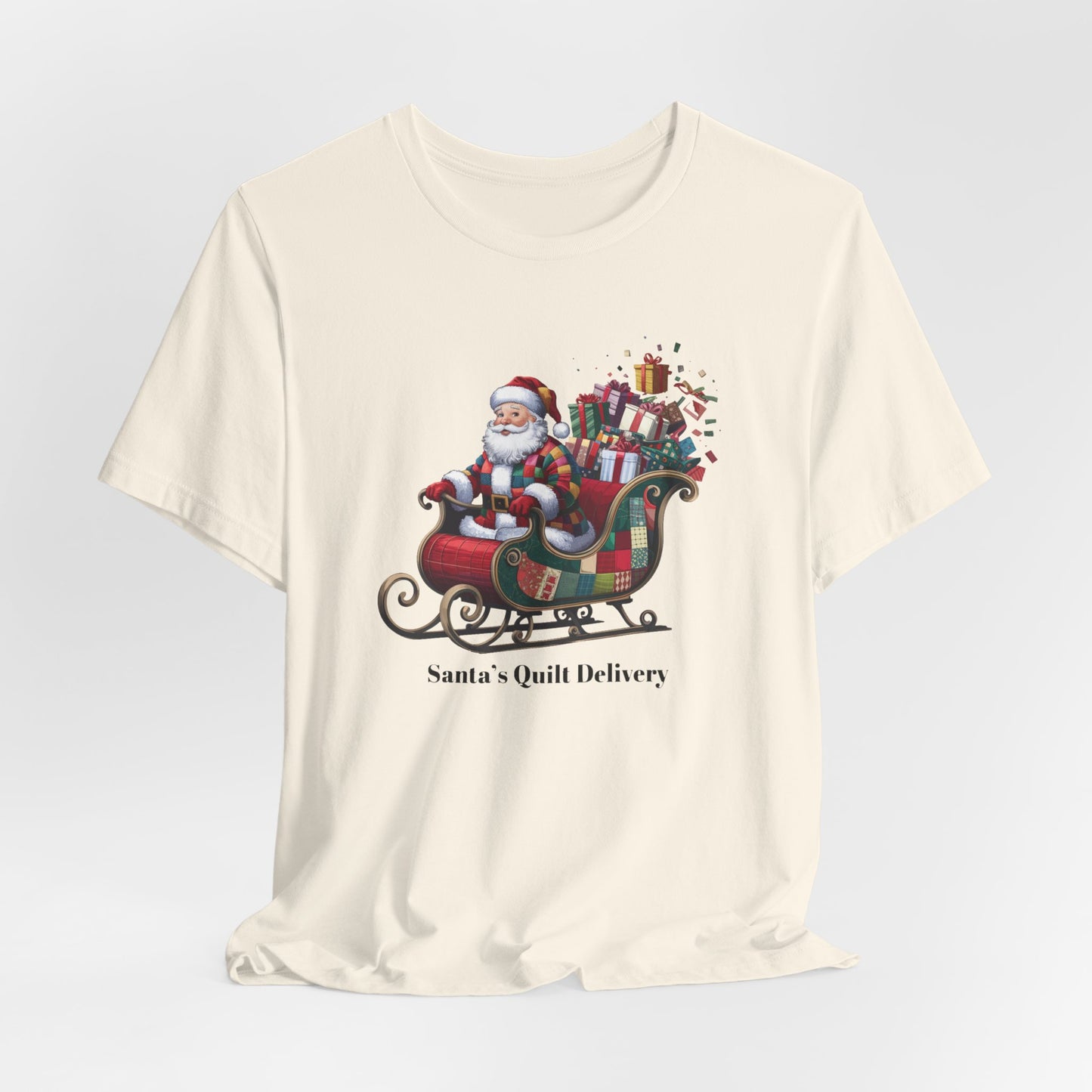 A christmas quilting t-shirt featuring Santa Claus wearing a patchwork quilt coat, sitting in a sleigh filled with gifts and quilts, with the phrase "Santa's Quilt Delivery" below, combining holiday cheer and quilting fun.