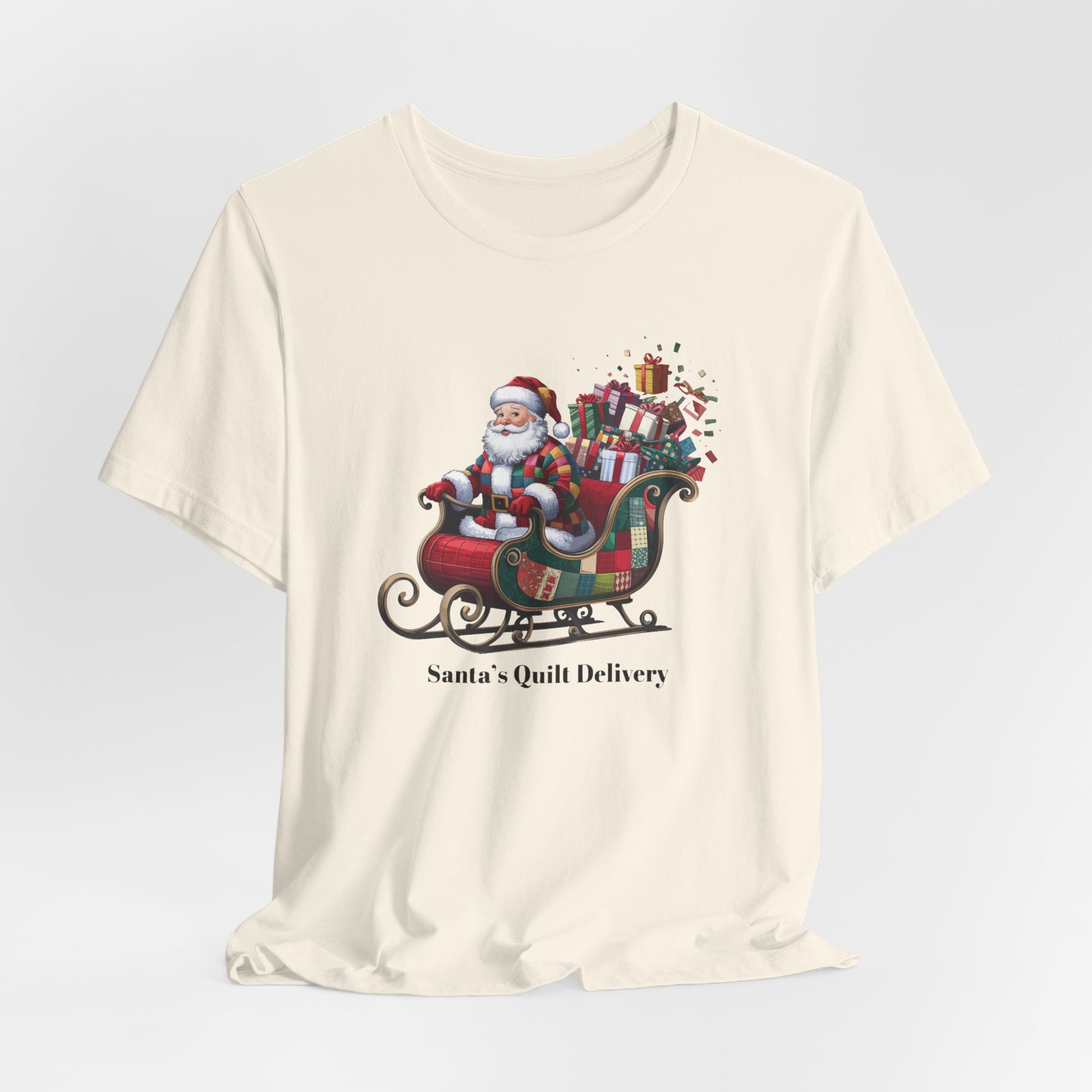 A christmas quilting t-shirt featuring Santa Claus wearing a patchwork quilt coat, sitting in a sleigh filled with gifts and quilts, with the phrase "Santa's Quilt Delivery" below, combining holiday cheer and quilting fun.