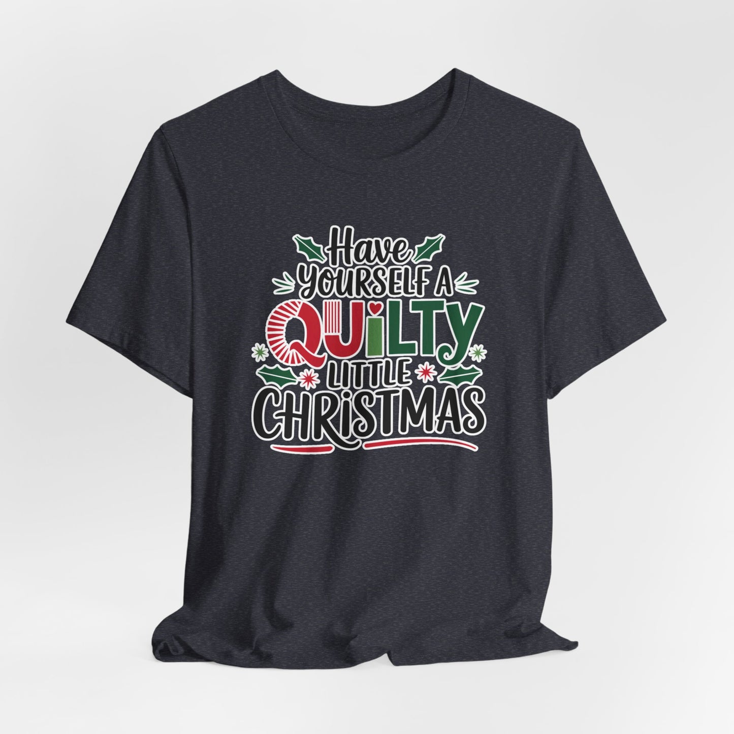 A Heather Navy fun holiday-themed t-shirt featuring the phrase "Have Yourself a Quilty Little Christmas" with quilting-inspired elements and holiday decorations such as holly and stars.
