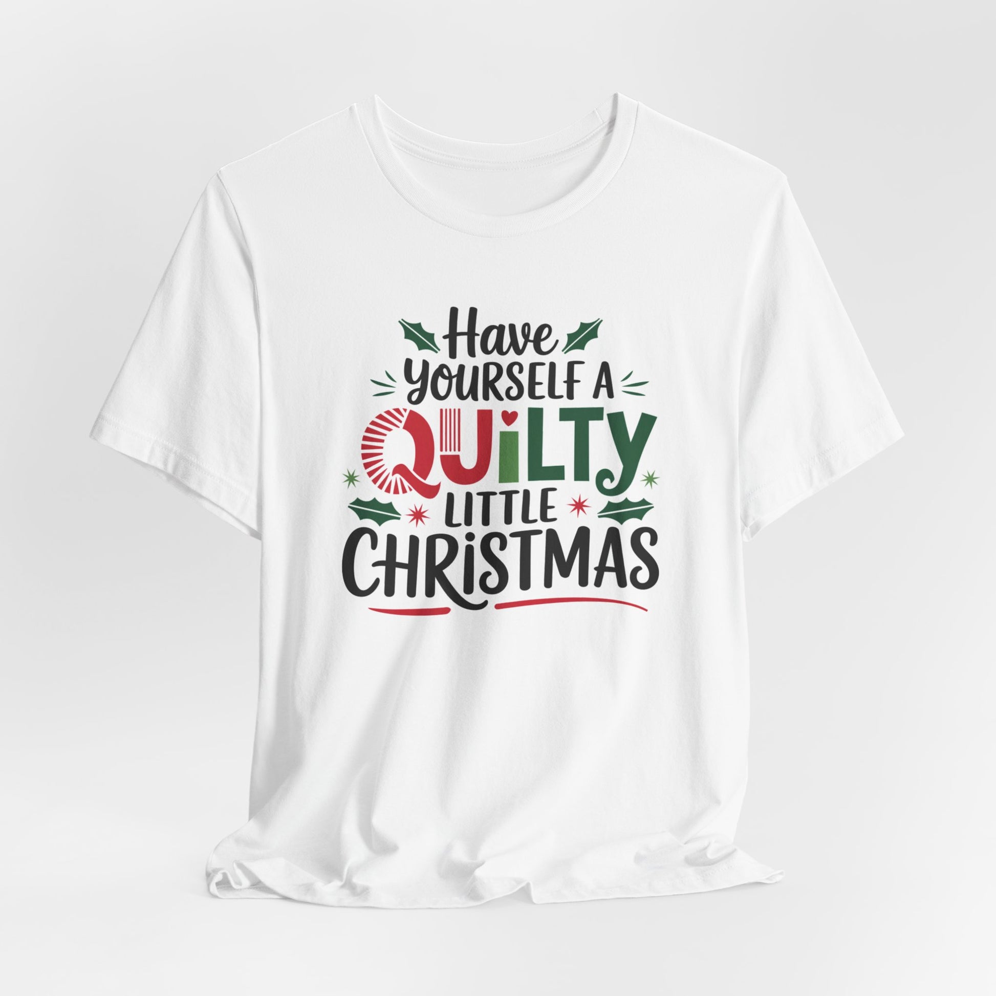 A White fun holiday-themed t-shirt featuring the phrase "Have Yourself a Quilty Little Christmas" with quilting-inspired elements and holiday decorations such as holly and stars.