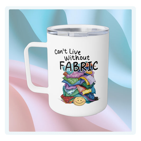 A funny quilting-inspired Insulated Mug with an Illustration of a smiling face underneath a pile of colorful fabric scraps. Text reads "Can't Live Without Fabric" in a handwritten style. The fabrics feature various patterns and textures in multiple colors.
