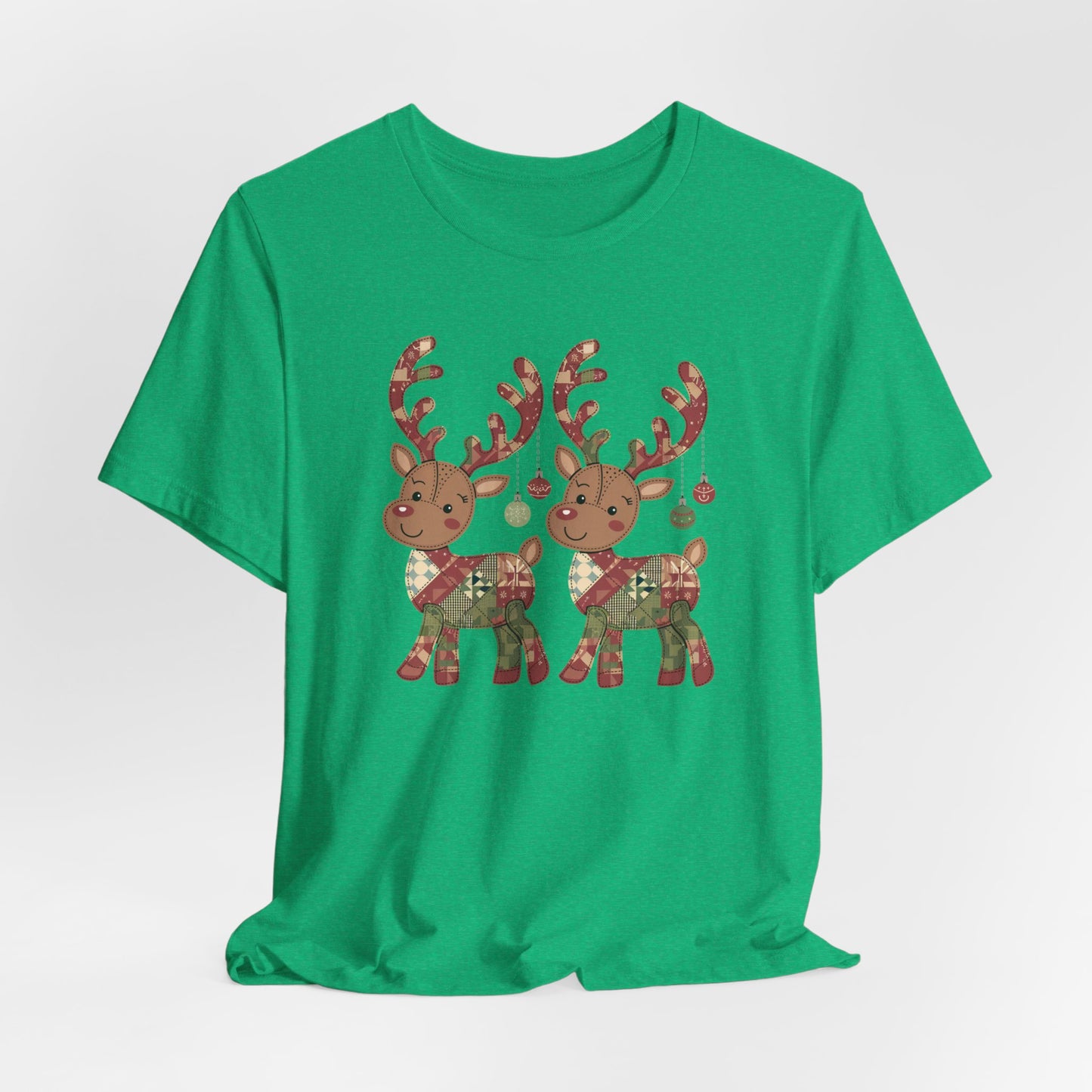 A Heather Kelly christmas quilting t-shirt featuring two adorable reindeer featuring patchwork quilt designs on their bodies, with ornaments hanging from their antlers, blending Christmas cheer with quilting creativity.