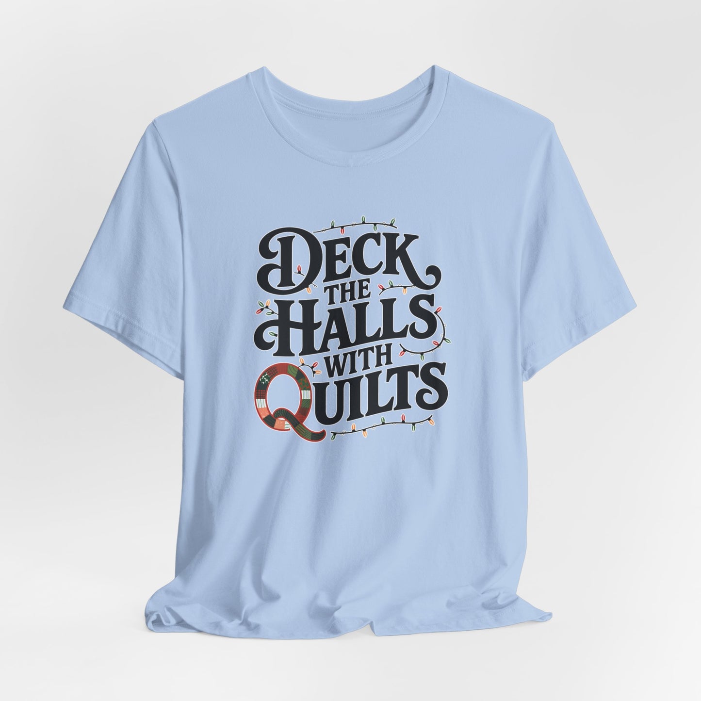 A Baby Blue christmas quilting t-shirt featuring the phrase "Deck the Halls with Quilts," adorned with holiday lights and quilting-inspired elements, including a quilted 'Q' for a humorous touch.