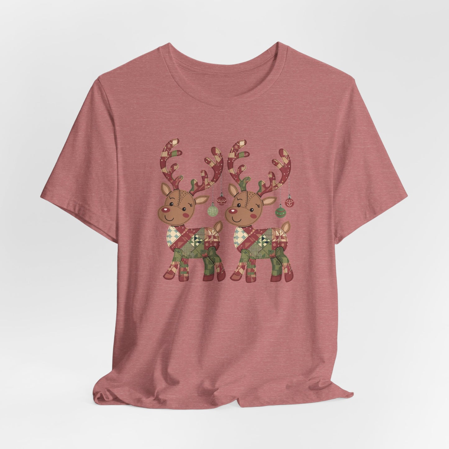 A Heather Mauve christmas quilting t-shirt featuring two adorable reindeer featuring patchwork quilt designs on their bodies, with ornaments hanging from their antlers, blending Christmas cheer with quilting creativity.