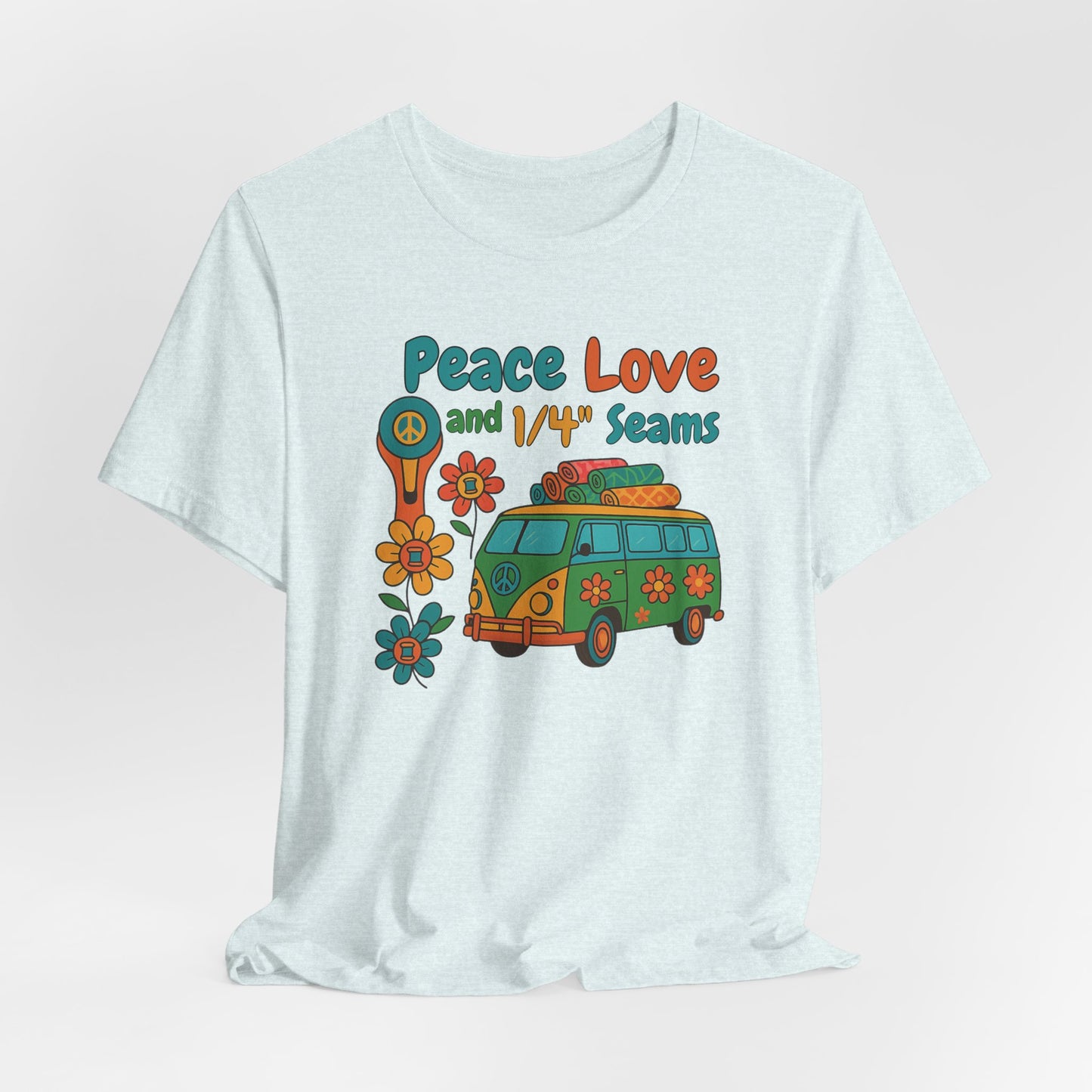 A A Heather Ice Blue t-shirt with colorful retro design showing a peace sign rotary cutter, patchwork van, and text “Peace Love and 1/4" Seams.” Surrounded by flowers made of thread spools. Fun vintage-style quilting shirt.
