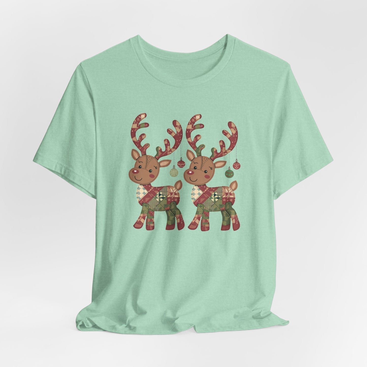 A Heather Mint christmas quilting t-shirt featuring two adorable reindeer featuring patchwork quilt designs on their bodies, with ornaments hanging from their antlers, blending Christmas cheer with quilting creativity.