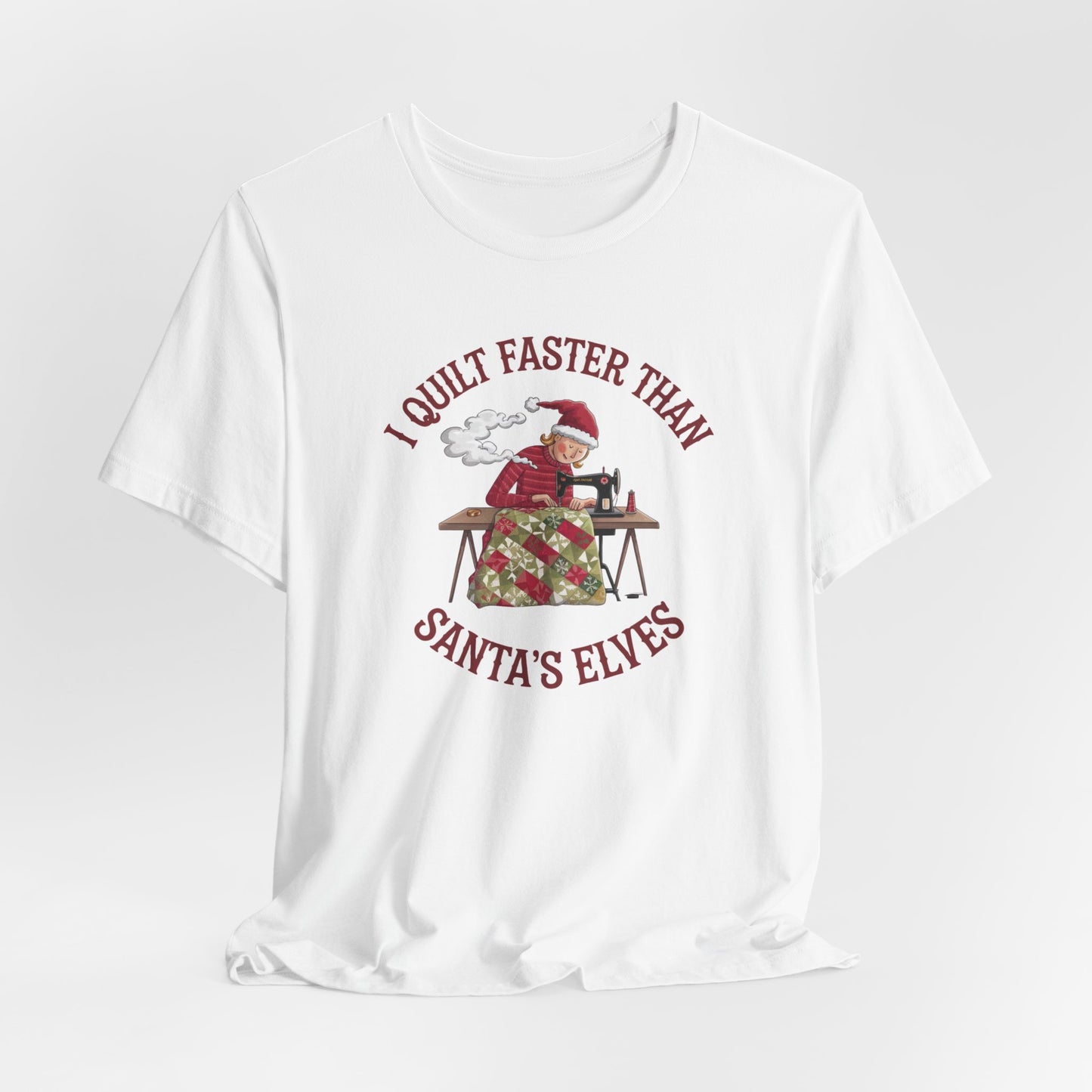 A White christmas quilting t-shirt featuring a quilter working at a sewing machine, quilting a festive holiday quilt, with the phrase "I Quilt Faster Than Santa's Elves" above the image, highlighting the speed and skill of the quilter.