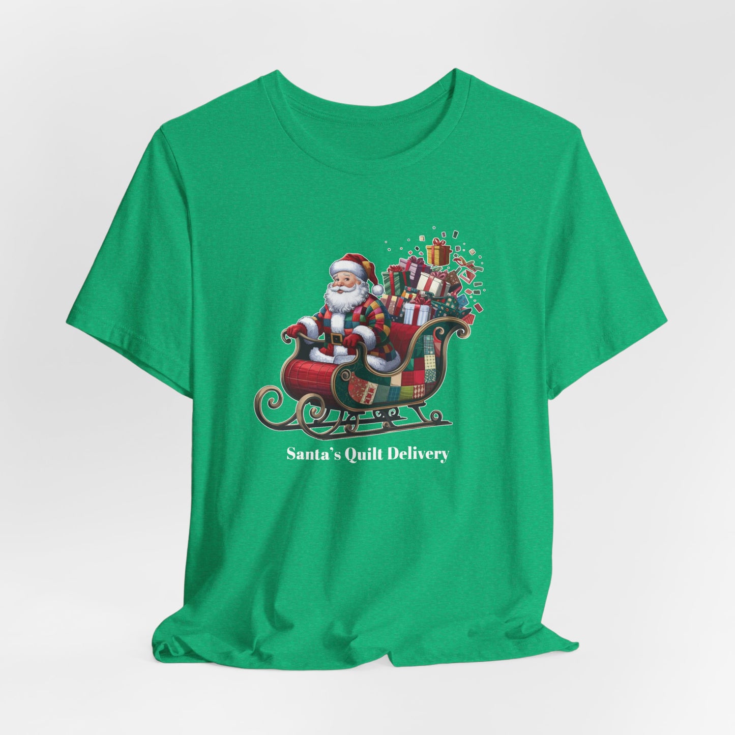 A Heather Kelly christmas quilting t-shirt featuring Santa Claus wearing a patchwork quilt coat, sitting in a sleigh filled with gifts and quilts, with the phrase "Santa's Quilt Delivery" below, combining holiday cheer and quilting fun.
