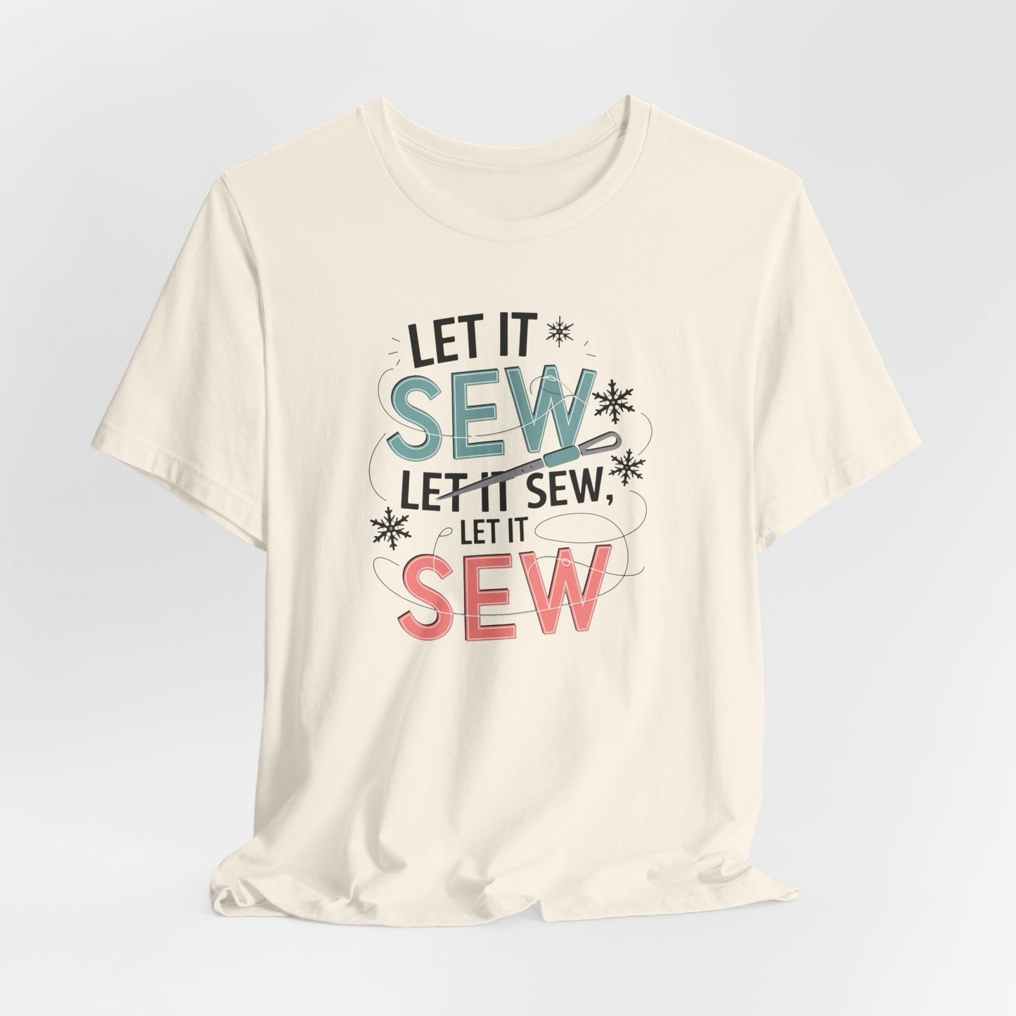 A Natural christmas quilting t-shirt featuring the phrase "Let it Sew, Let it Sew, Let it Sew" featuring a needle and thread weaving through the letters, accented by snowflakes to bring out the holiday theme.