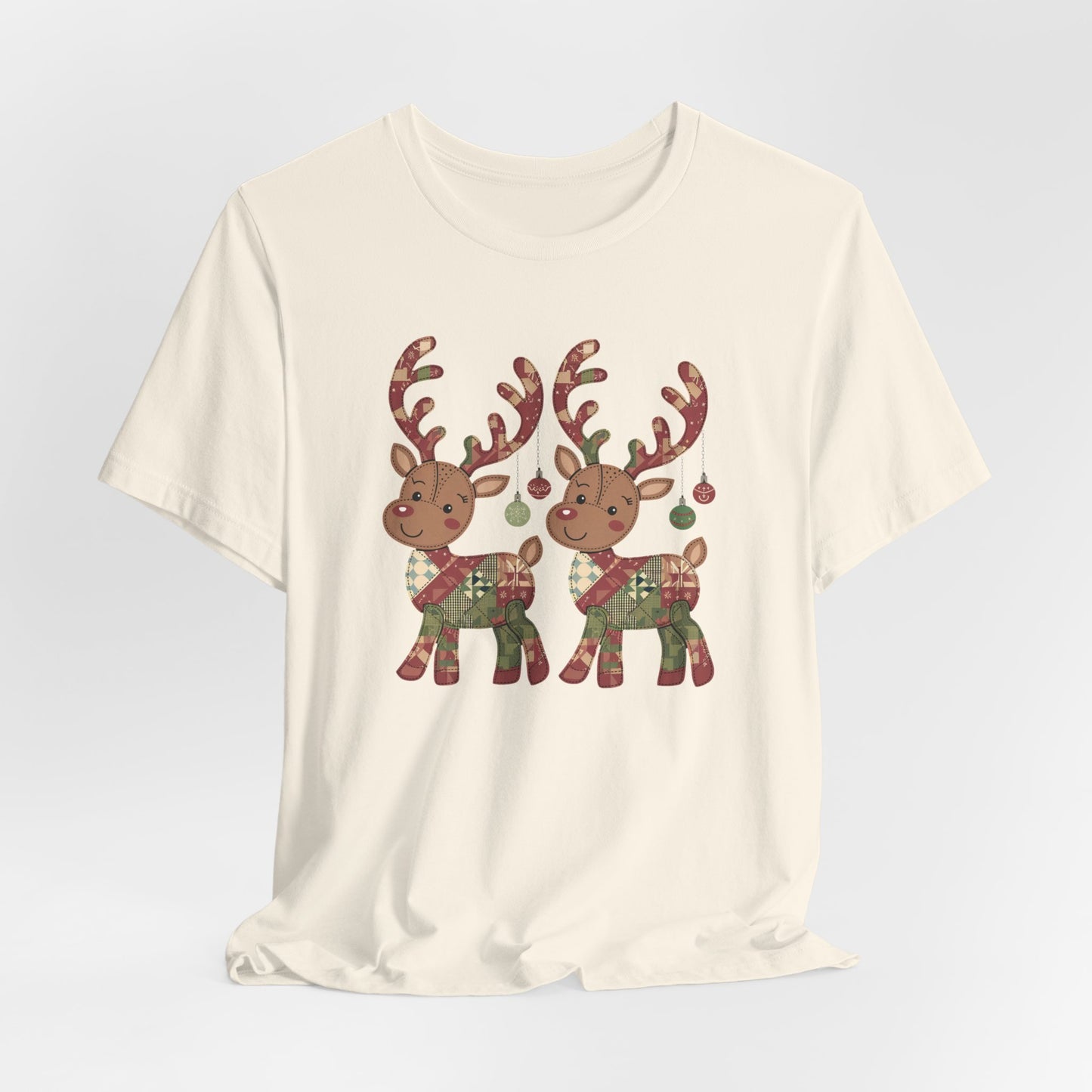 A Natural christmas quilting t-shirt featuring two adorable reindeer featuring patchwork quilt designs on their bodies, with ornaments hanging from their antlers, blending Christmas cheer with quilting creativity.