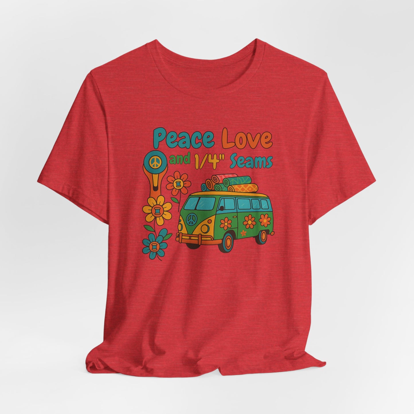 A A Heather Red t-shirt with colorful retro design showing a peace sign rotary cutter, patchwork van, and text “Peace Love and 1/4" Seams.” Surrounded by flowers made of thread spools. Fun vintage-style quilting shirt.