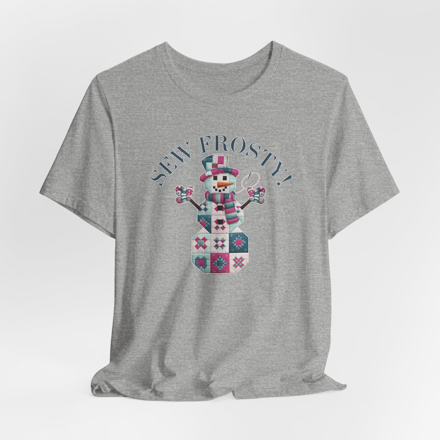 An Athletic Heather christmas quilting t-shirt featuring cute snowman made of patchwork quilt blocks with the phrase "Sew Frosty" above, holding a needle to highlight the quilting theme.