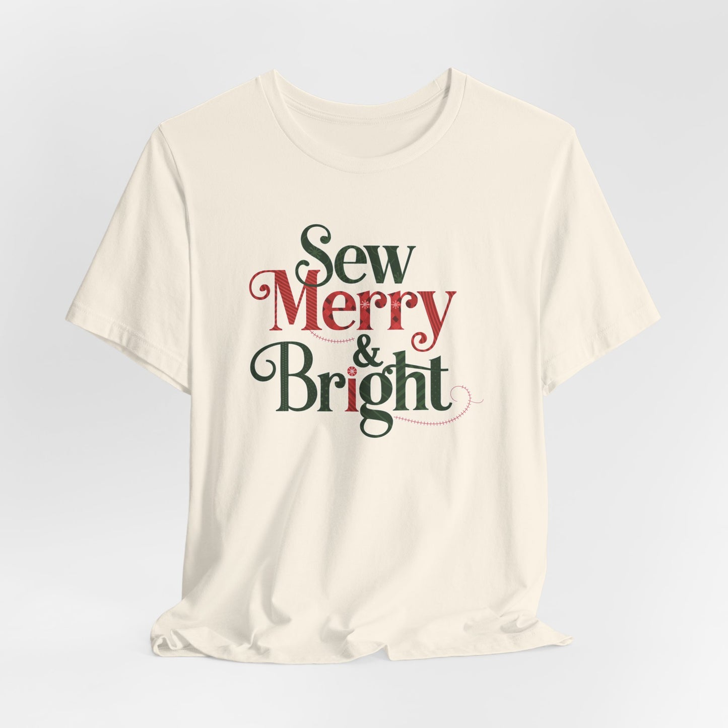 A Natural t-shirt with the phrase "Sew Merry & Bright," incorporating sewing-inspired elements and holiday-themed accents, such as stitching lines and festive patterns.