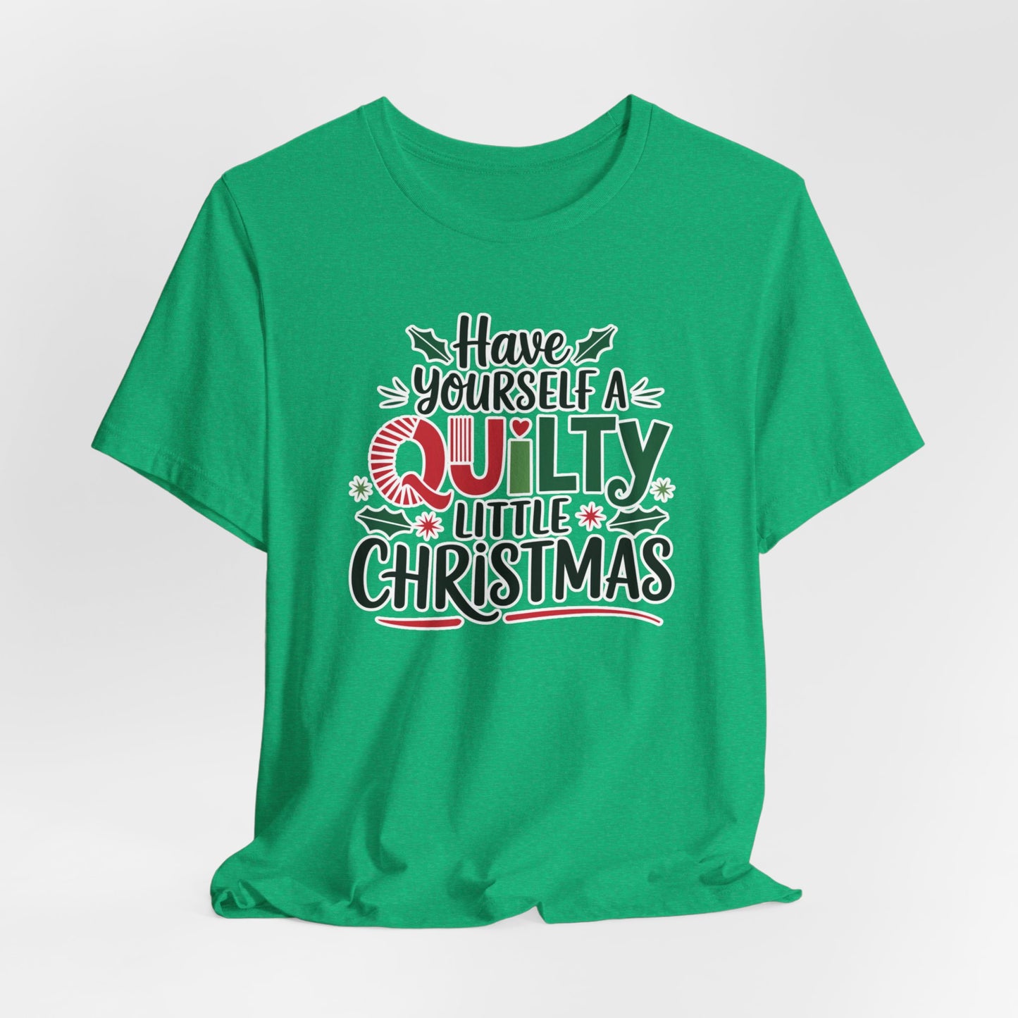 A Heather Kelly fun holiday-themed t-shirt featuring the phrase "Have Yourself a Quilty Little Christmas" with quilting-inspired elements and holiday decorations such as holly and stars.
