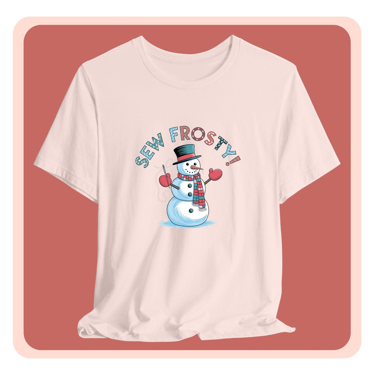 A christmas quilting t-shirt featuring cheerful snowman design holding a sewing needle, with the phrase "Sew Frosty" in playful, winter-themed lettering. The snowman is wearing a scarf and mittens, ready for holiday sewing fun.