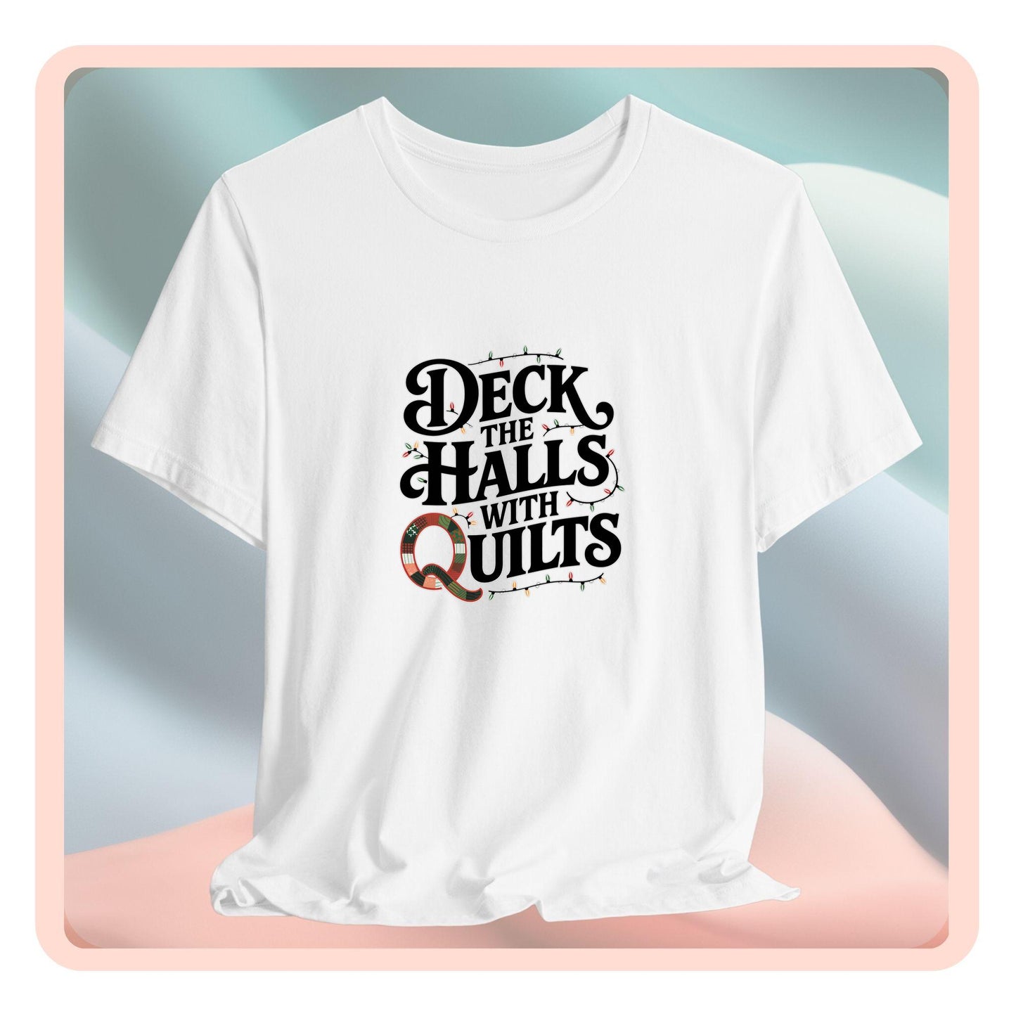A christmas quilting t-shirt featuring the phrase "Deck the Halls with Quilts," adorned with holiday lights and quilting-inspired elements, including a quilted 'Q' for a humorous touch.