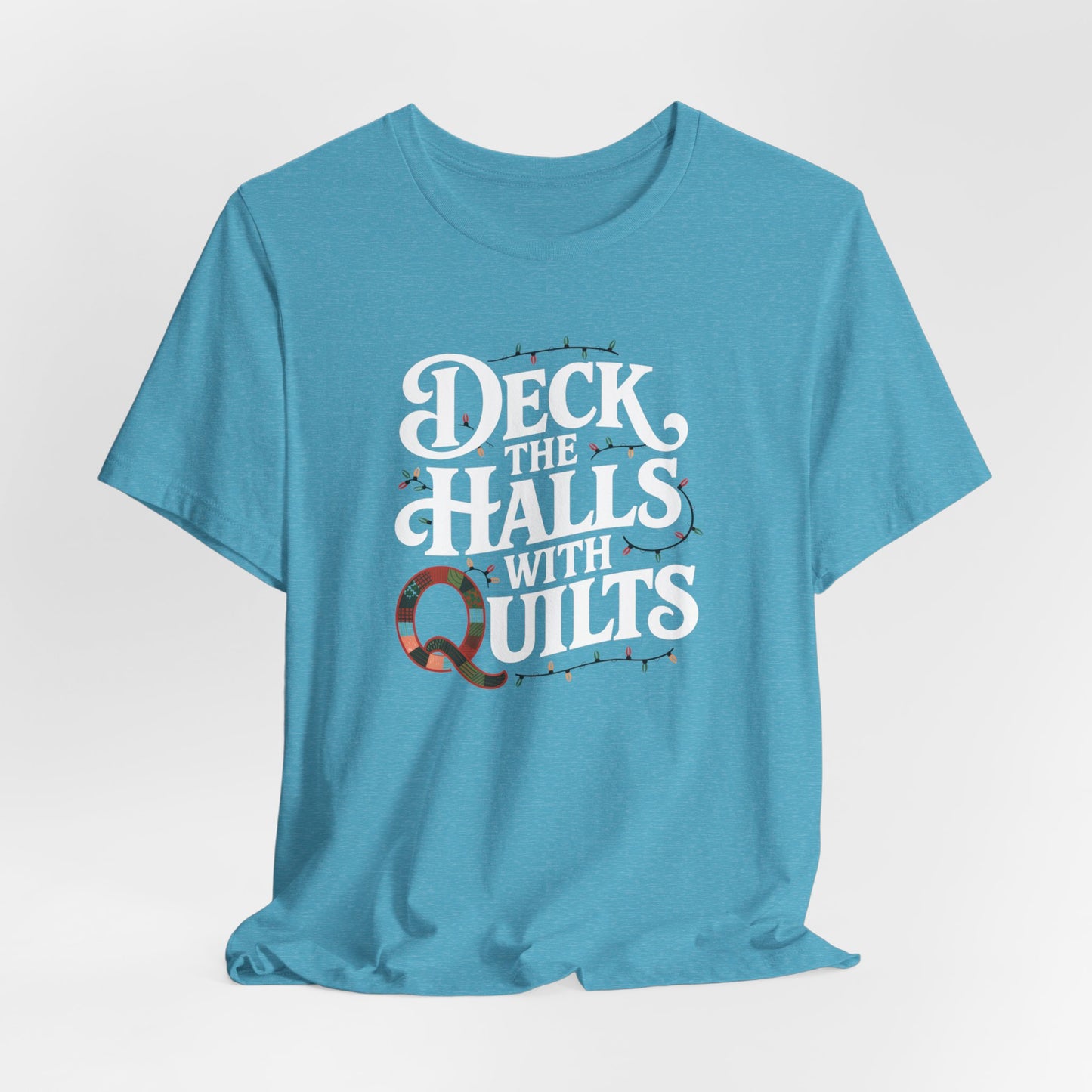 A Heather Aqua christmas quilting t-shirt featuring the phrase "Deck the Halls with Quilts," adorned with holiday lights and quilting-inspired elements, including a quilted 'Q' for a humorous touch.