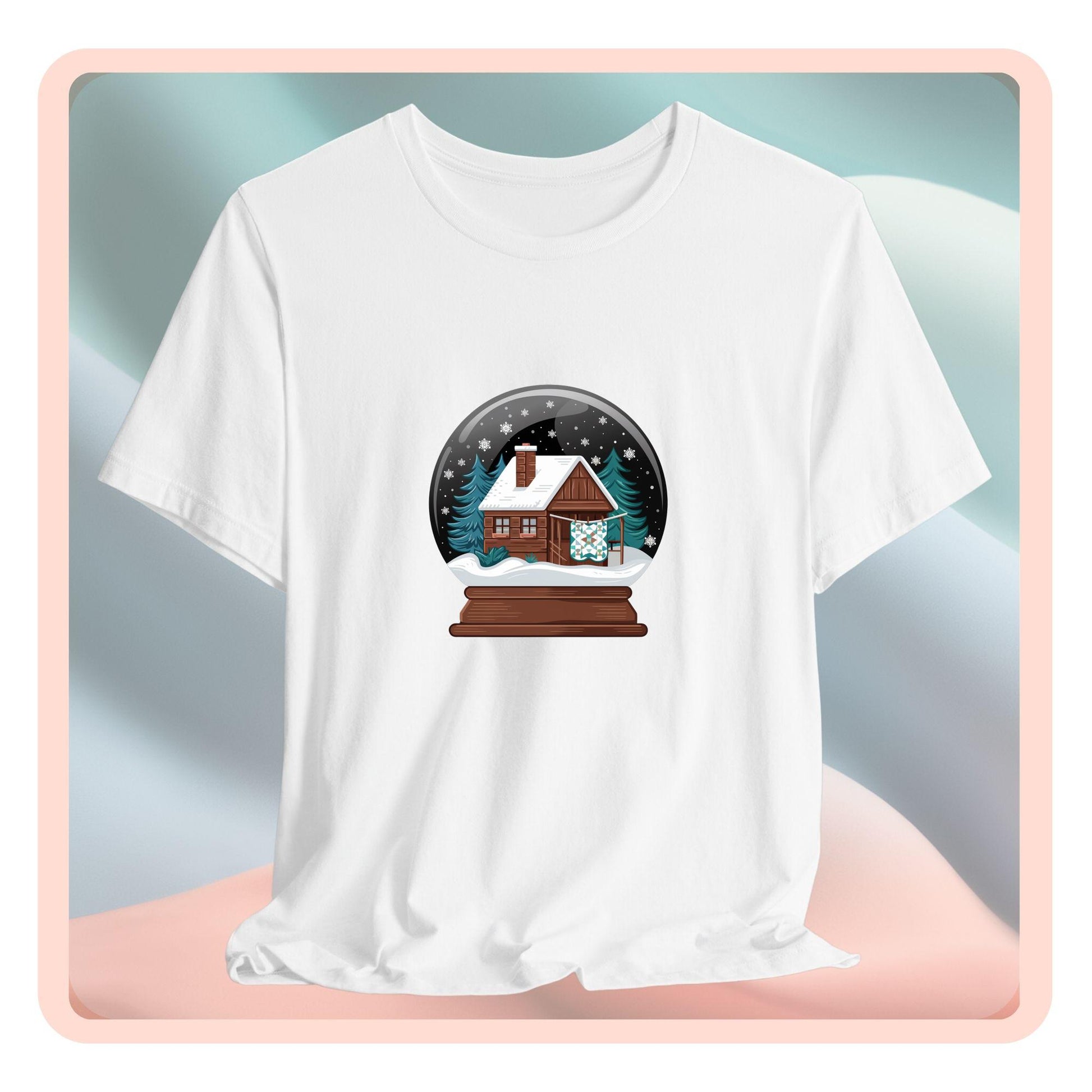 A christmas quilting t-shirt featuring a cozy log cabin covered in snow, with a quilt hanging outside, set inside a snow globe with swirling snowflakes, blending quilting and holiday warmth.