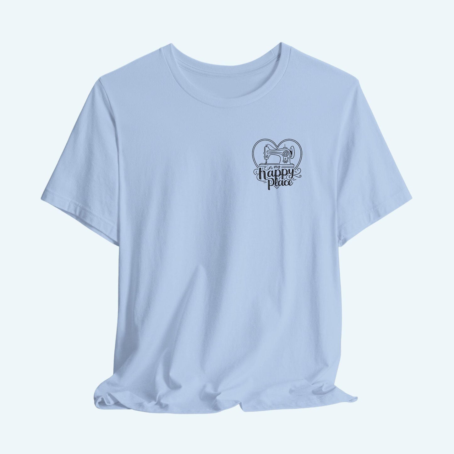 A funny quilting T-shirt design showing a sewing machine inside a heart shape with decorative swirls. Text reads "In my happy place" in mixed fonts, emphasizing quilting as a source of joy and contentment for enthusiasts.
