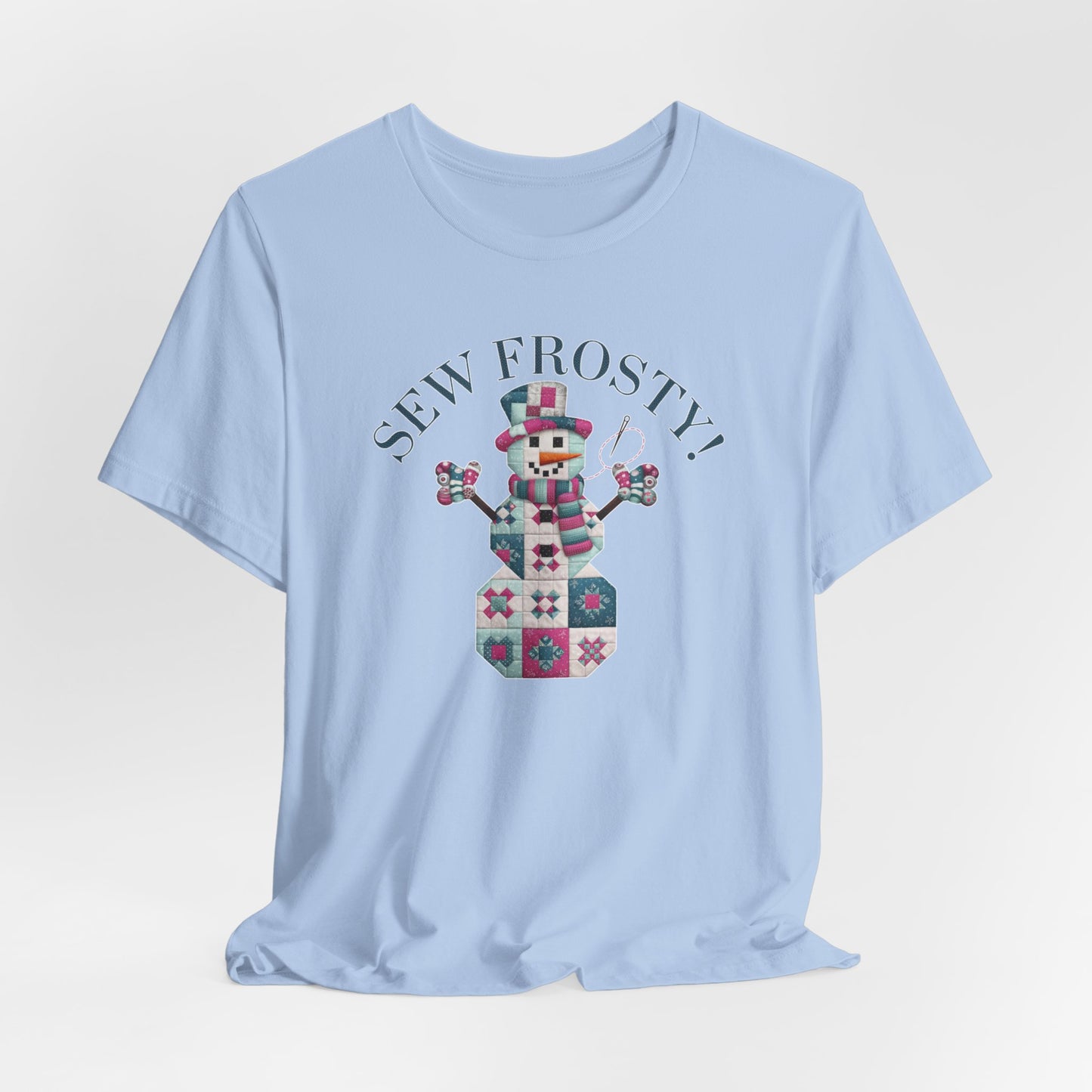 A Baby Blue christmas quilting t-shirt featuring cute snowman made of patchwork quilt blocks with the phrase "Sew Frosty" above, holding a needle to highlight the quilting theme.