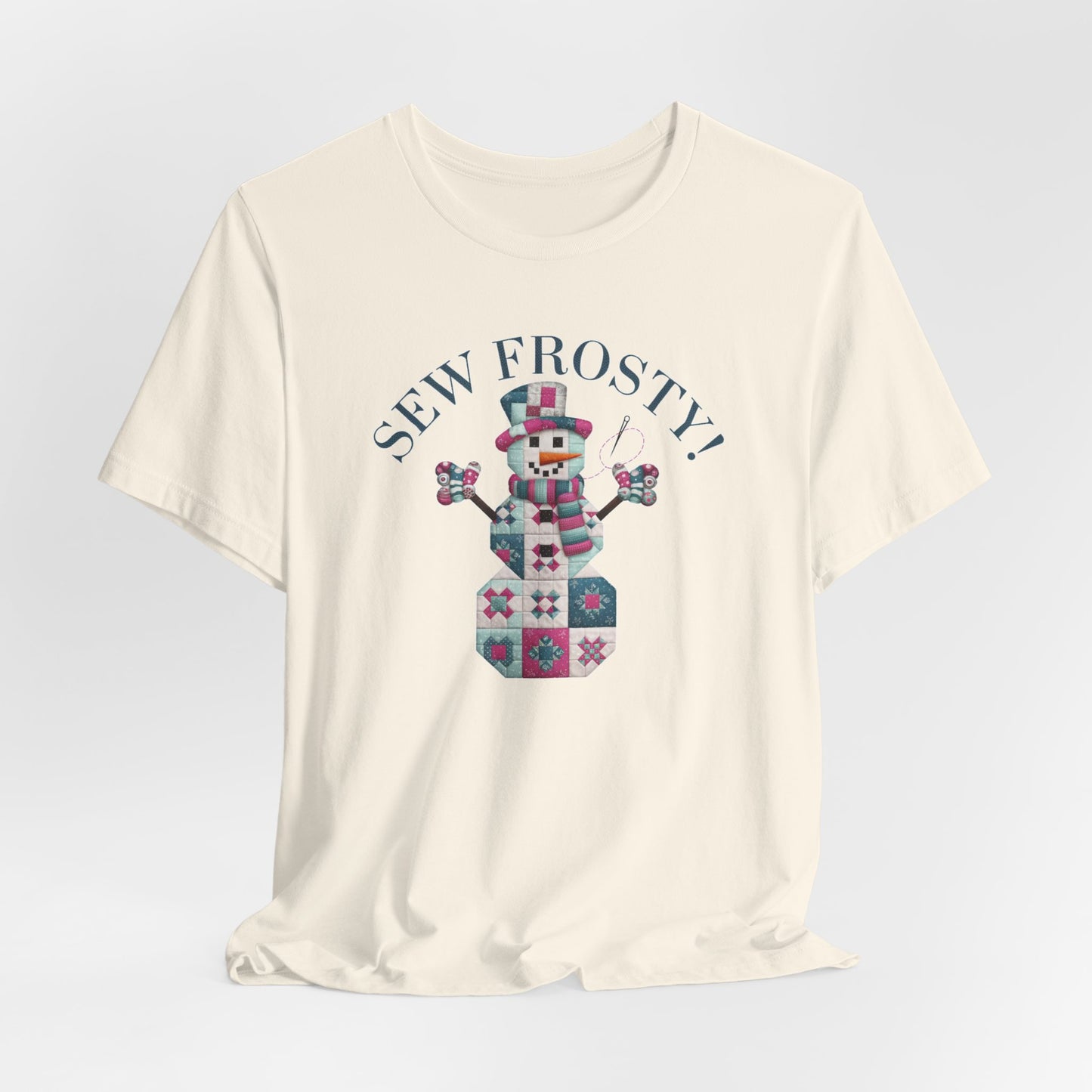 A Natural christmas quilting t-shirt featuring cute snowman made of patchwork quilt blocks with the phrase "Sew Frosty" above, holding a needle to highlight the quilting theme.