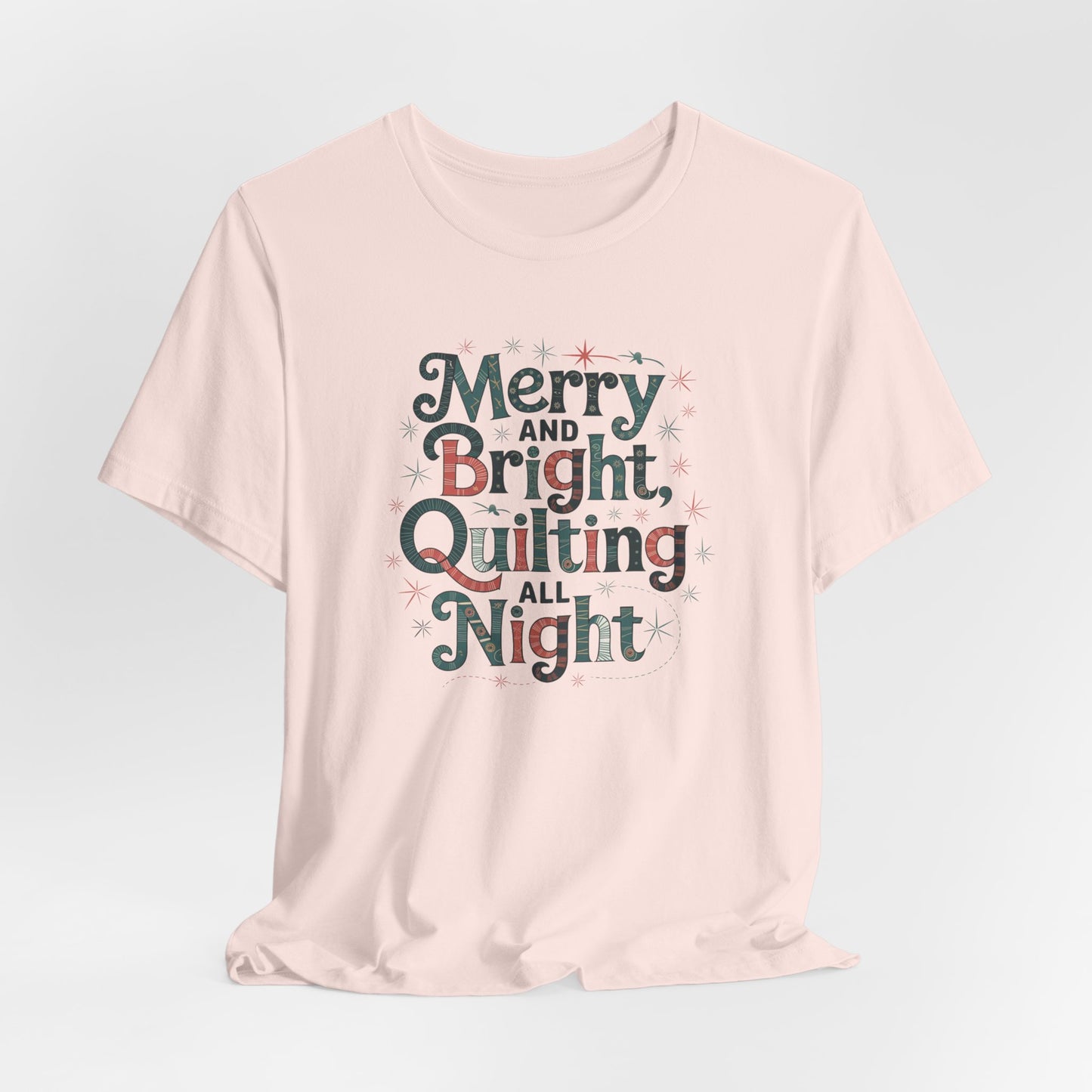 A Soft Pink christmas quilting T-shirt featuring a whimsical design with the phrase "Merry and Bright, Quilting All Night," featuring festive quilting patterns and holiday-themed elements like stars and stitching lines. Perfect gift for quilters.