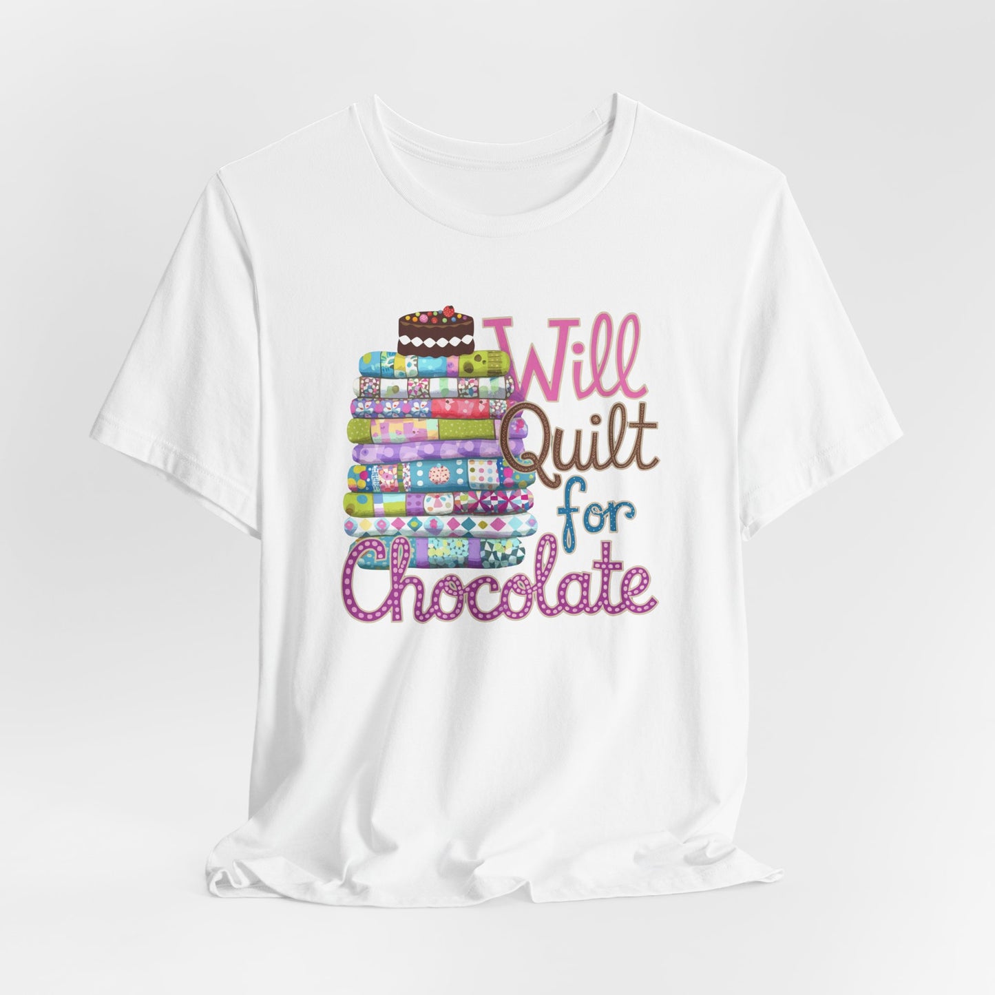 A White t-shirt featuring a whimsical design of a colorful stack of quilts topped with a chocolate cake and the phrase 'Will Quilt for Chocolate,' perfect for quilters who love sweets.