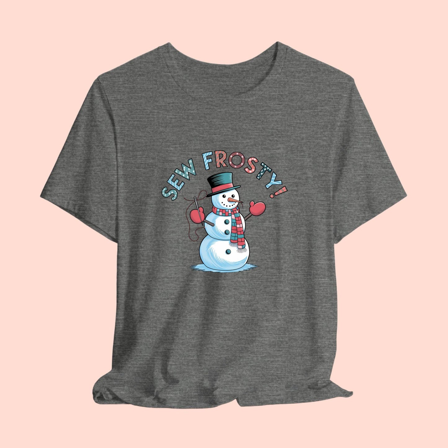 A christmas quilting t-shirt featuring cheerful snowman design holding a sewing needle, with the phrase "Sew Frosty" in playful, winter-themed lettering. The snowman is wearing a scarf and mittens, ready for holiday sewing fun.