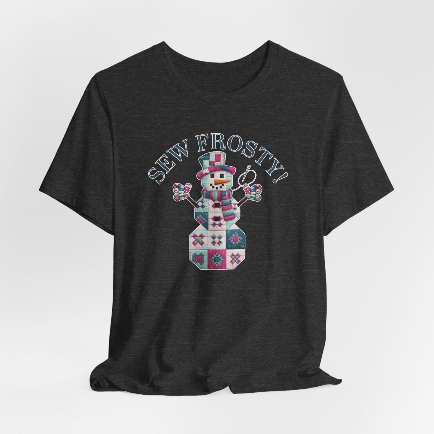 A Dark Grey Heather christmas quilting t-shirt featuring cute snowman made of patchwork quilt blocks with the phrase "Sew Frosty" above, holding a needle to highlight the quilting theme.