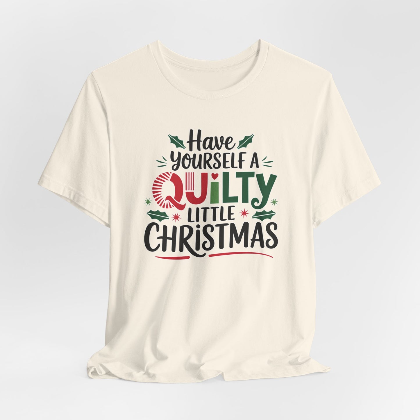 A Natural fun holiday-themed t-shirt featuring the phrase "Have Yourself a Quilty Little Christmas" with quilting-inspired elements and holiday decorations such as holly and stars.