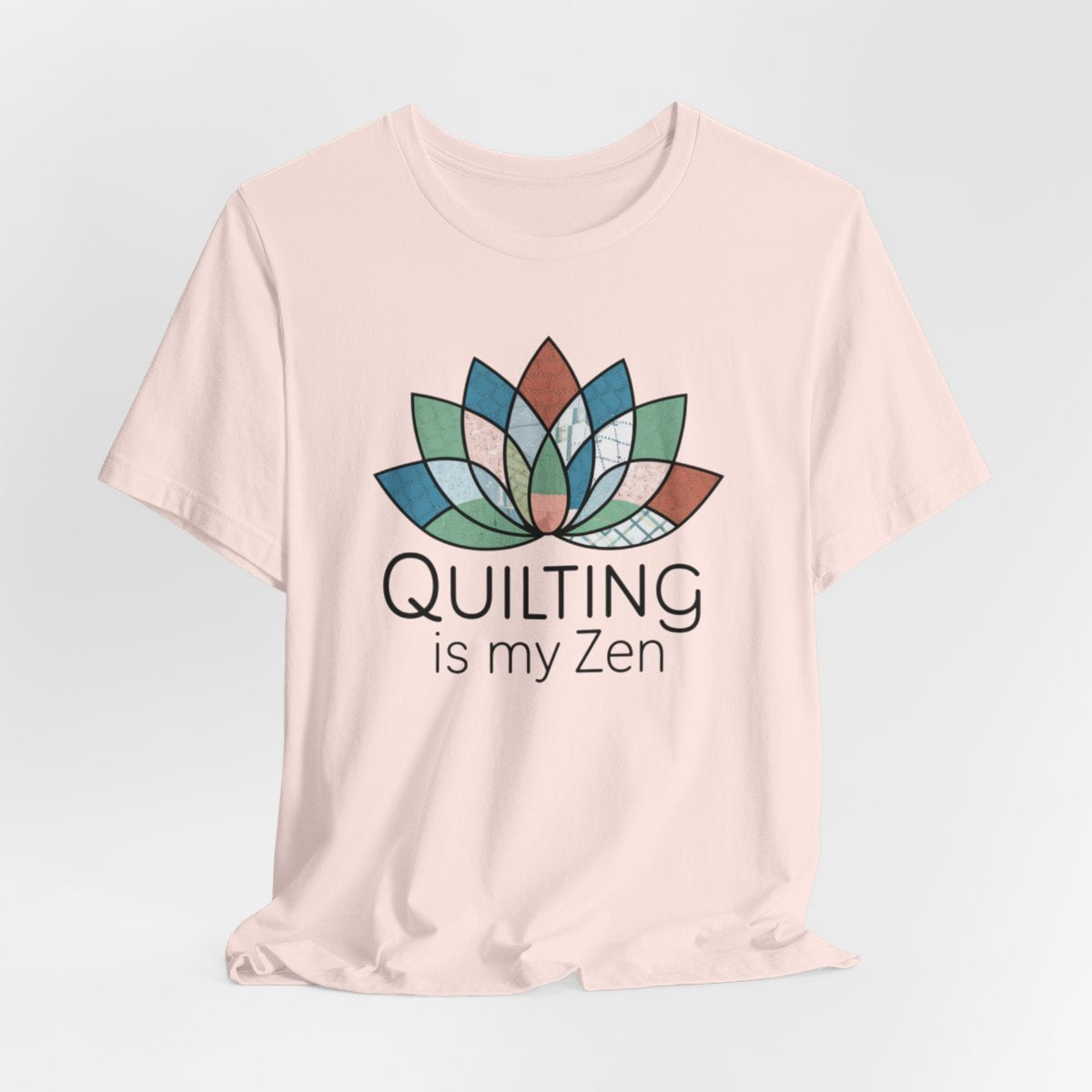 A Soft Pink funny quilting T-Shirt with the phrase Quilting is my Zen on a quilting-themed t-shirt with a lotus flower design made of various quilt patterns and textures.