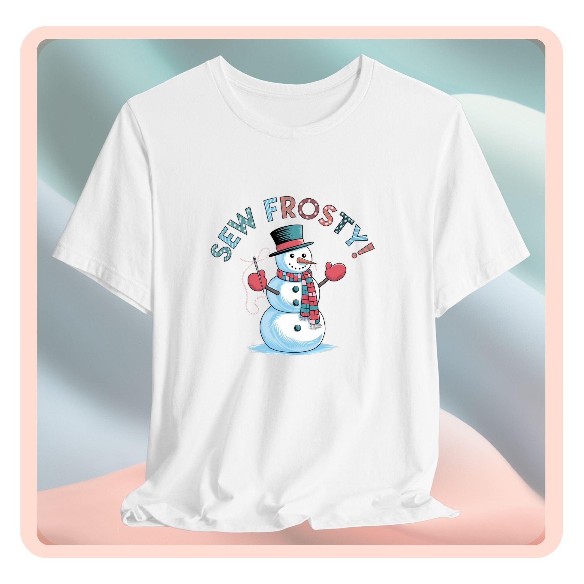 A christmas quilting t-shirt featuring cheerful snowman design holding a sewing needle, with the phrase "Sew Frosty" in playful, winter-themed lettering. The snowman is wearing a scarf and mittens, ready for holiday sewing fun.
