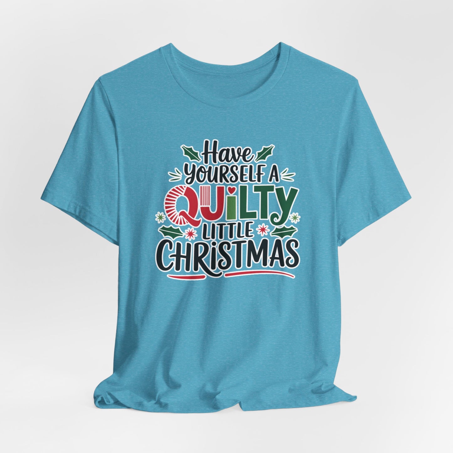A Heather Aqua fun holiday-themed t-shirt featuring the phrase "Have Yourself a Quilty Little Christmas" with quilting-inspired elements and holiday decorations such as holly and stars.