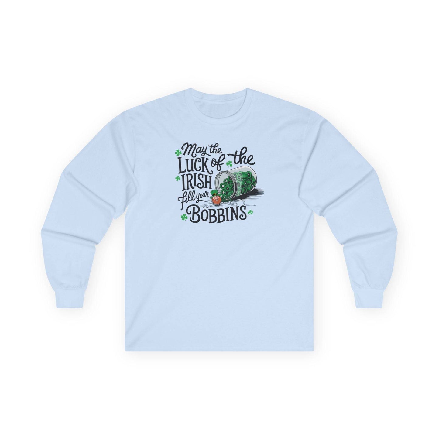 A Light Blue long-sleeve t-shirt featuring a festive design with shamrocks, a spool of green thread, and the phrase 'May the Luck of the Irish Fill Your Bobbins,' perfect for quilters celebrating St. Patrick’s Day.