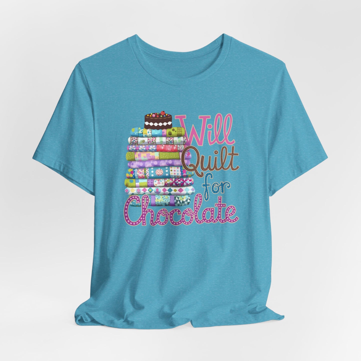 A Heather Aqua t-shirt featuring a whimsical design of a colorful stack of quilts topped with a chocolate cake and the phrase 'Will Quilt for Chocolate,' perfect for quilters who love sweets.