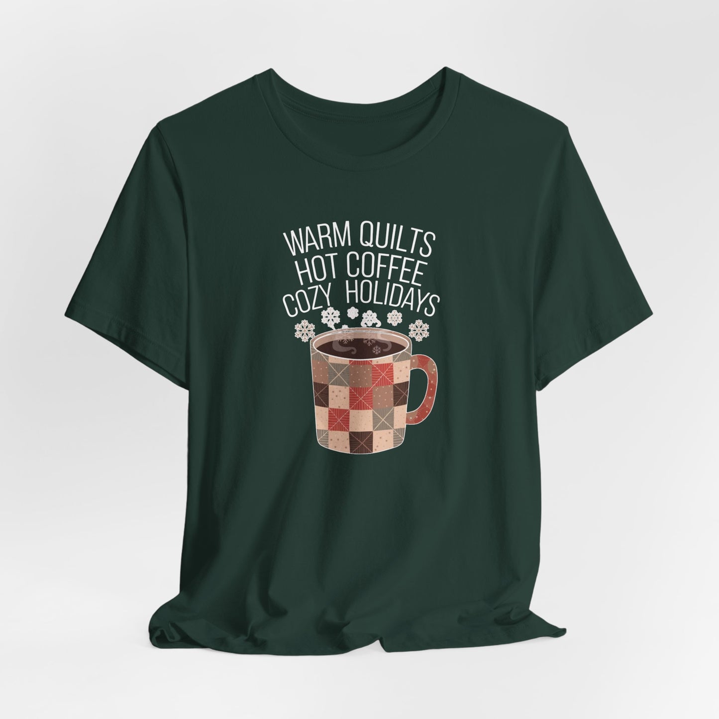 A Forest christmas quilting t-shirt featuring a cozy patchwork quilt-themed coffee mug, surrounded by snowflakes, with the phrase "Warm Quilts, Hot Coffee, Cozy Holidays" above the mug, celebrating the warmth of quilts and coffee during the holiday season.