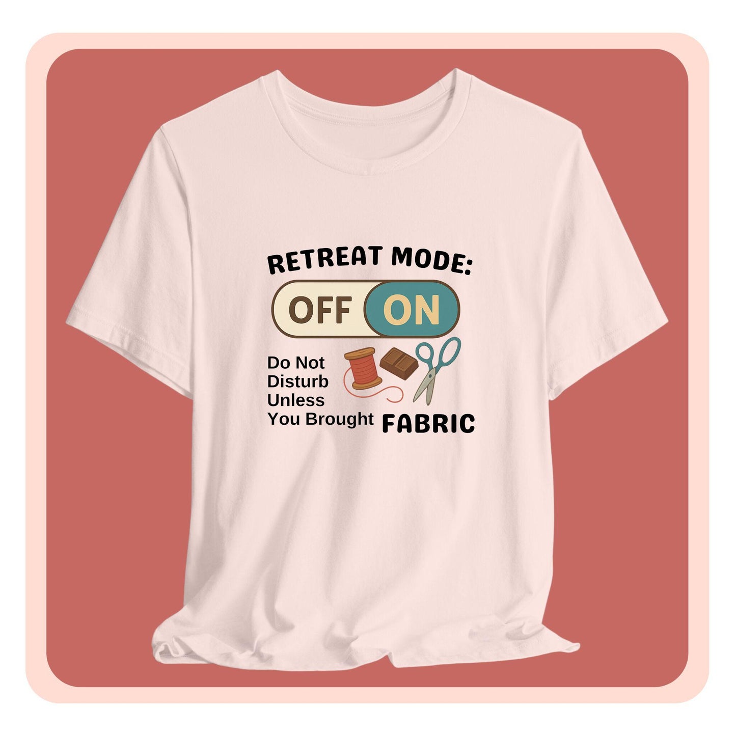 A A t-shirt with a toggle switch that says "Retreat Mode: OFF/ON" surrounded by a spool of thread, chocolate, and scissors. Text below reads "Do not disturb unless you brought fabric." Fun gift for quilting retreats.