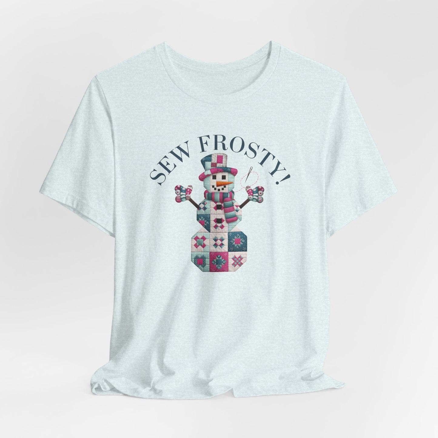 A Heather Ice Blue christmas quilting t-shirt featuring cute snowman made of patchwork quilt blocks with the phrase "Sew Frosty" above, holding a needle to highlight the quilting theme.