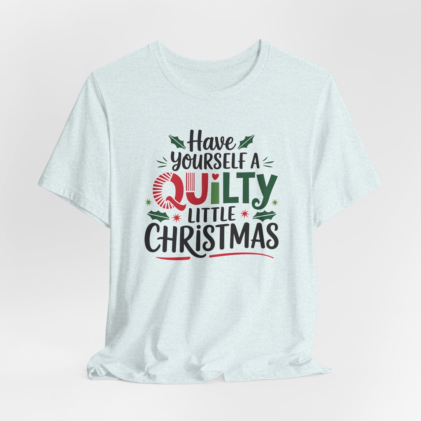 A Heather Ice Blue fun holiday-themed t-shirt featuring the phrase "Have Yourself a Quilty Little Christmas" with quilting-inspired elements and holiday decorations such as holly and stars.