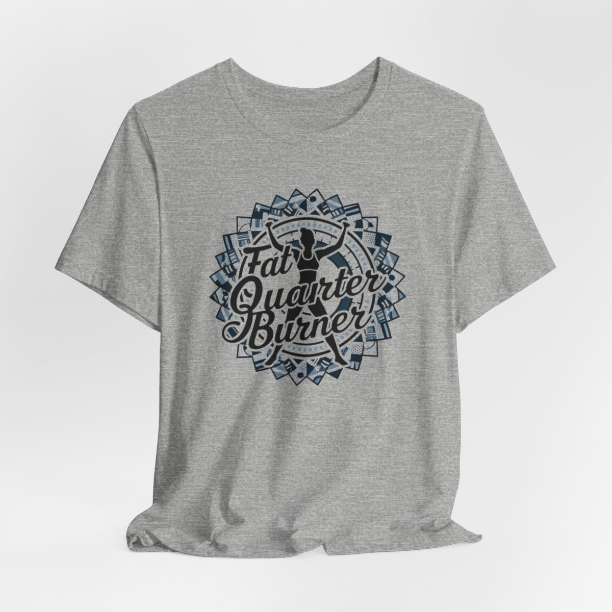 An Athletic Heather T-Shirt featuring a patchwork border surrounding silhouette of woman lifting weights. Text reads "Fat Quarter Burner" in bold script.