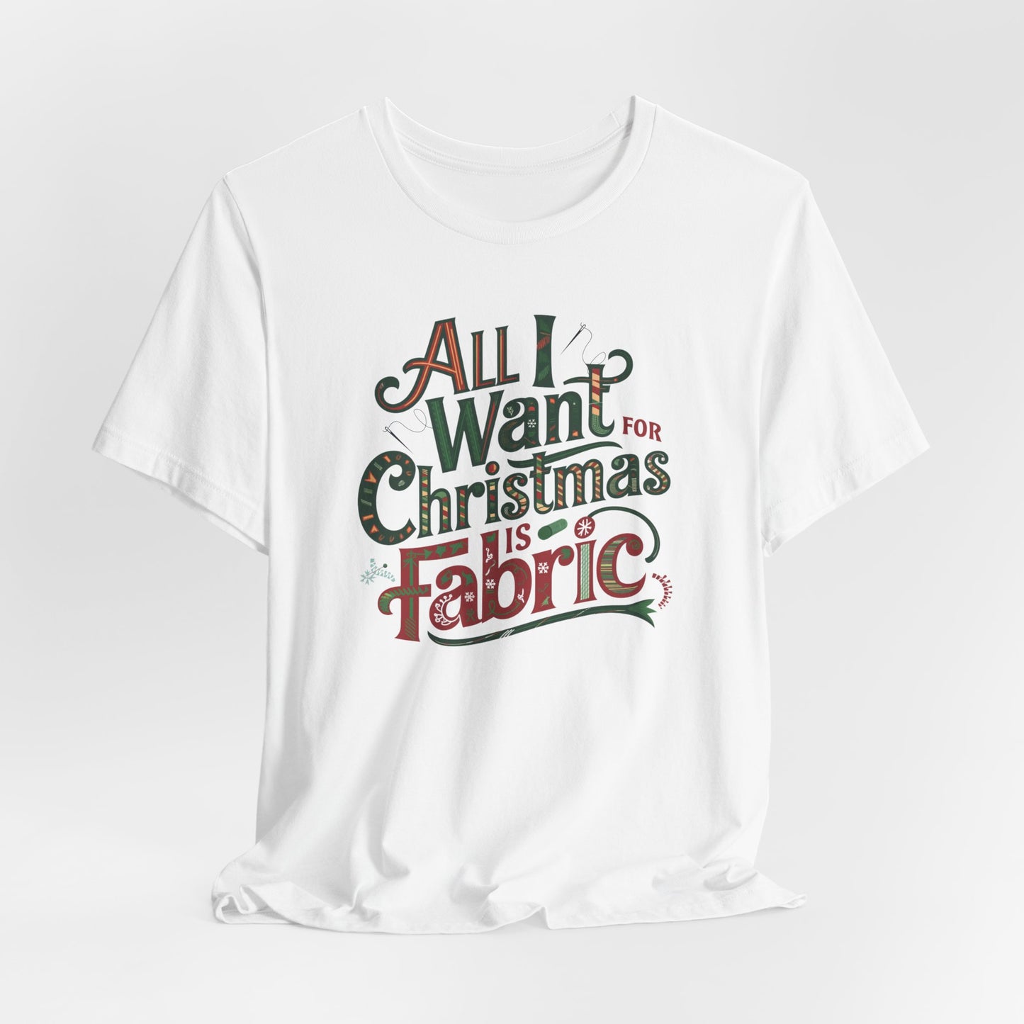 A White festive quilting christmas T-shirt featuring the phrase "All I Want for Christmas is Fabric," with fun sewing and quilting accents like needles and threads swirling around the text.