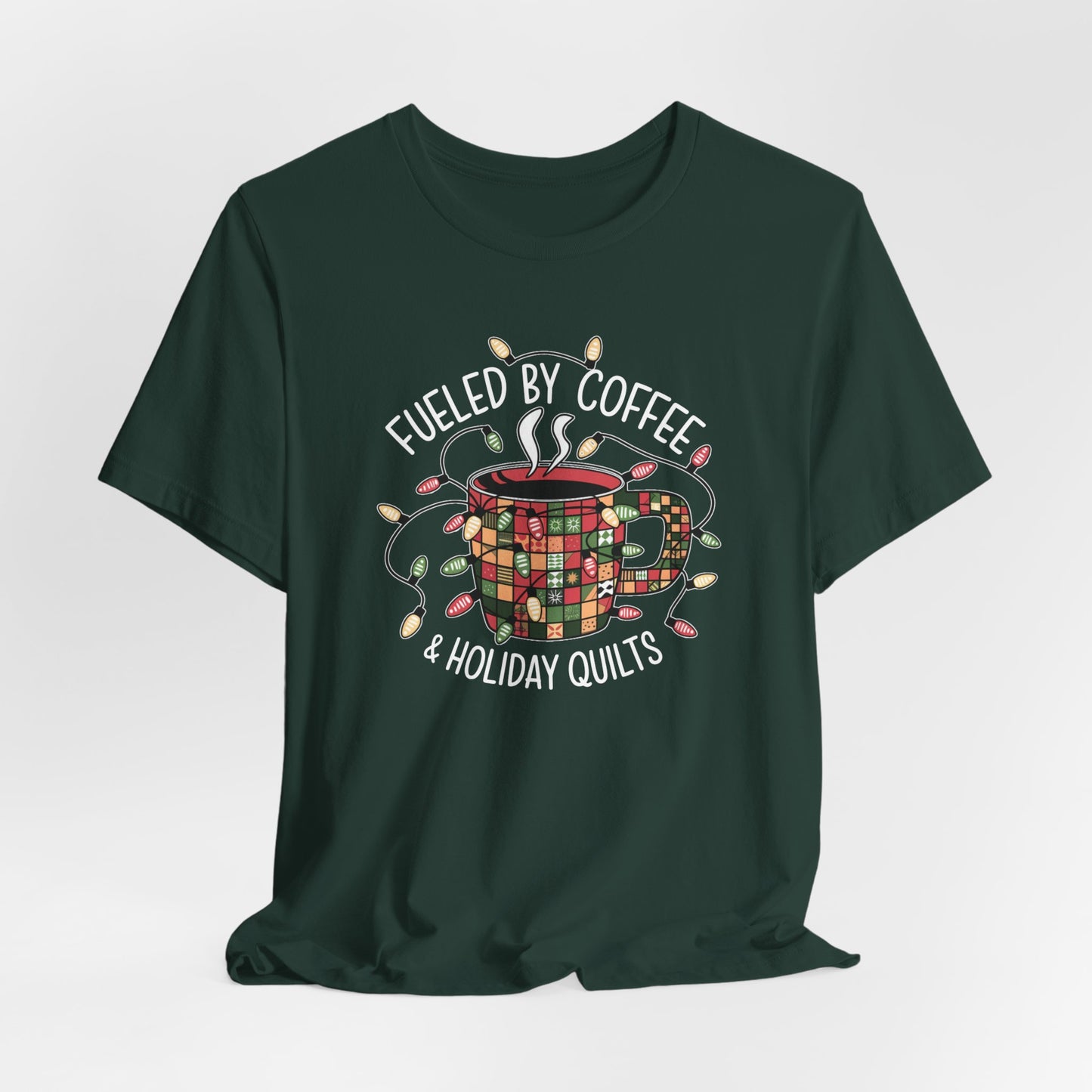 A Forest christmas quilting t-shirt featuring a cozy coffee mug covered in patchwork quilt patterns, wrapped in festive holiday lights, with the phrase "Fueled by Coffee & Holiday Quilts" surrounding the design.